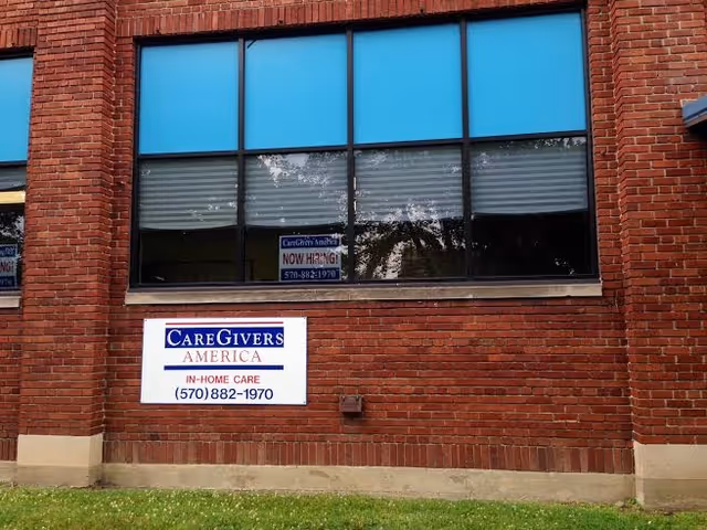 Brick building exterior with large windows and a CareGivers America in-home care sign