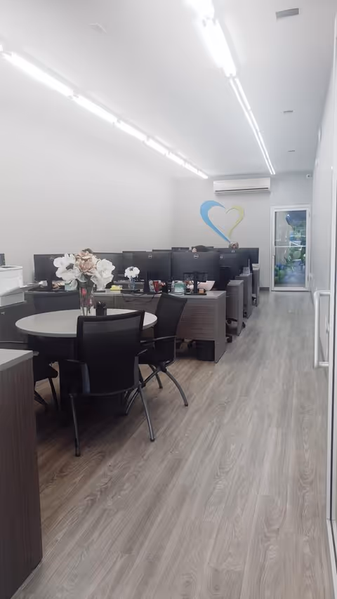 Bright interior office area with computer desks, chairs, and a round table.