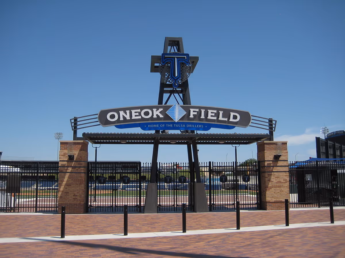 Entrance to ONEOK Field stadium with brick pillars, metal gate, and a curved sign.
