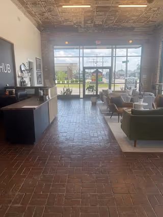 Modern senior living lobby with reception desk, brick flooring, and seating area.