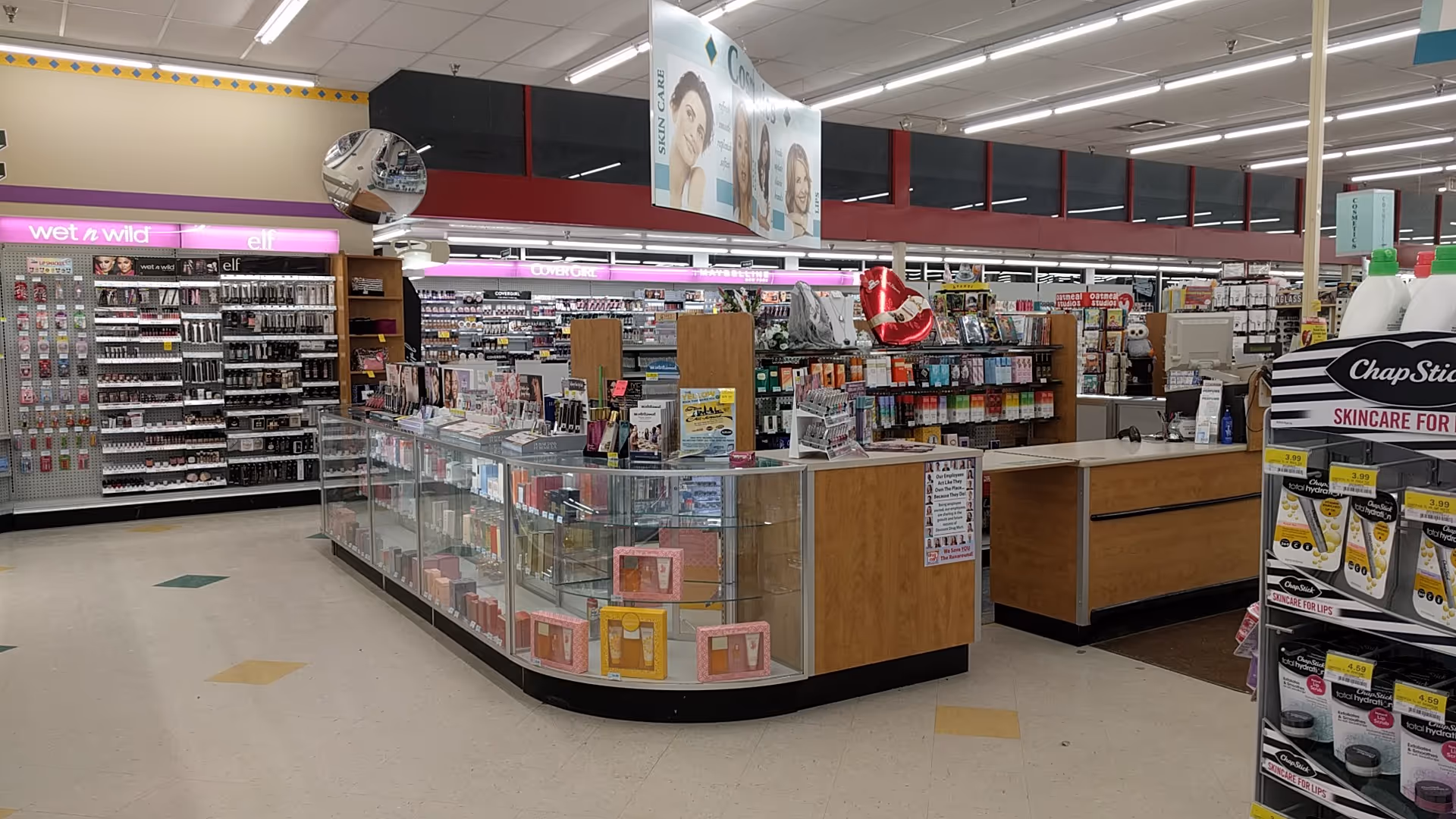 Inside a Discount Drug Mart pharmacy, glass display counters line a checkout area.