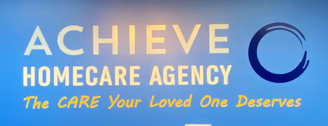 Blue wall sign displaying ACHIEVE Homecare Agency and circular logo.