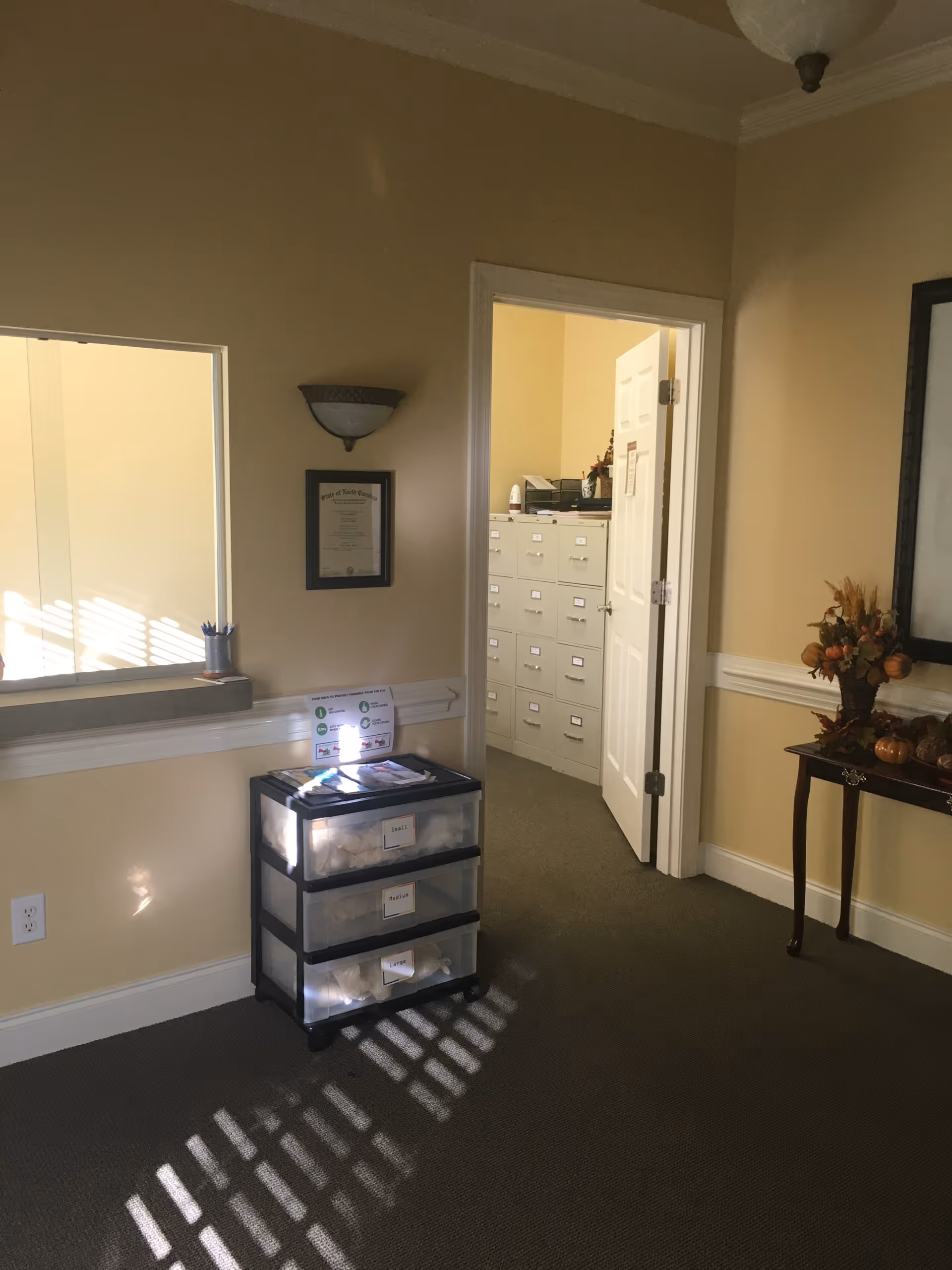 hallway interior of a senior facility with a rolling storage cart and filing cabinets