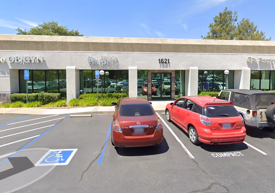 Senior Helpers facility storefront with glass doors, parking lot, and tree-lined exterior