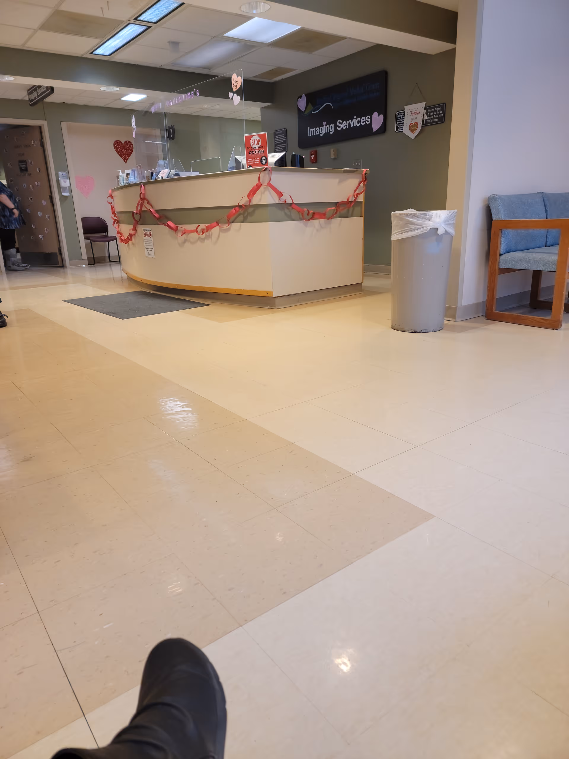 Curved reception desk in Bradford Regional Medical Center lobby decorated with garland and imaging services sign.
