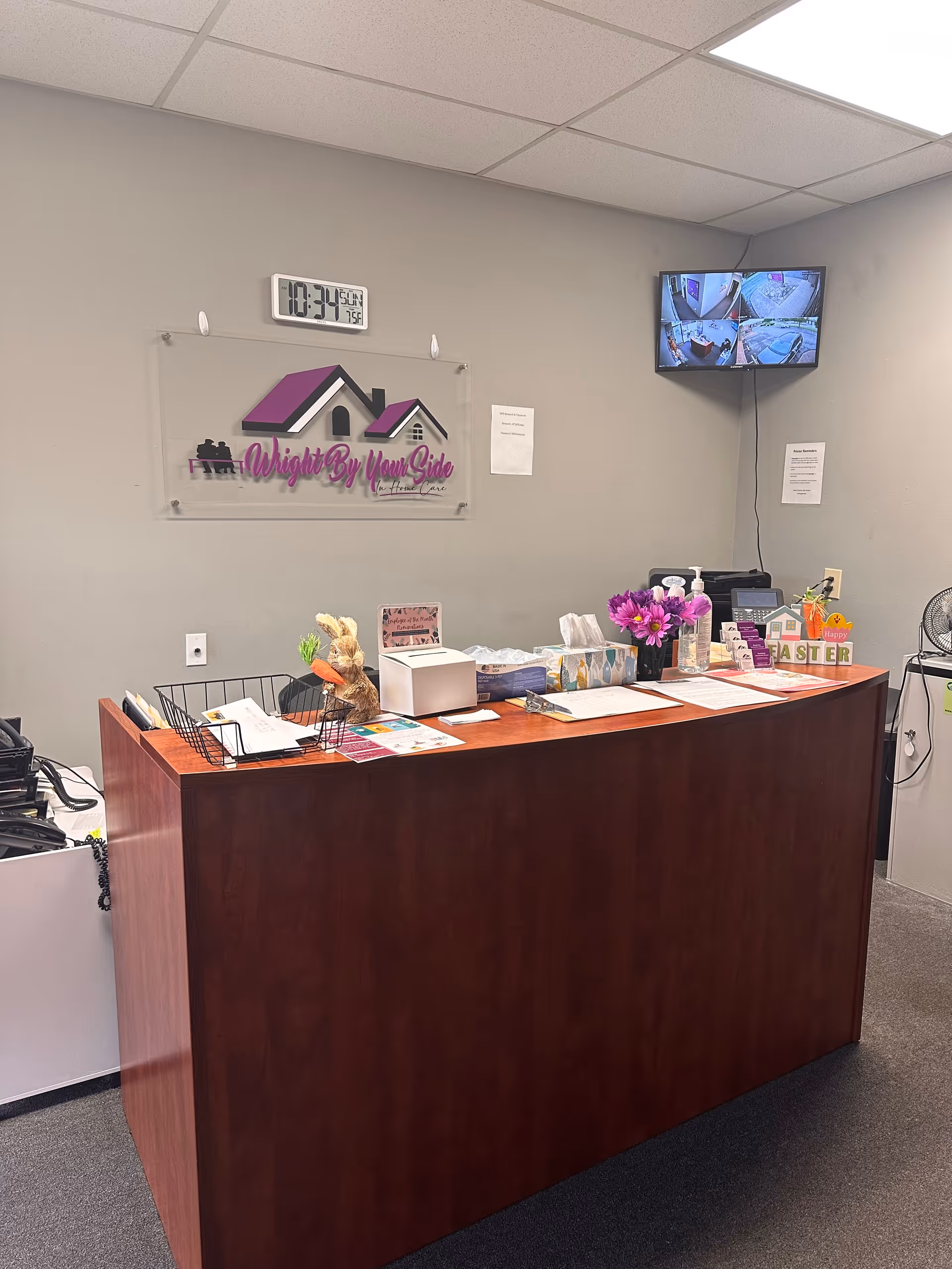 Reception desk inside Wright By Your Side In Home Care facility with sign and monitor