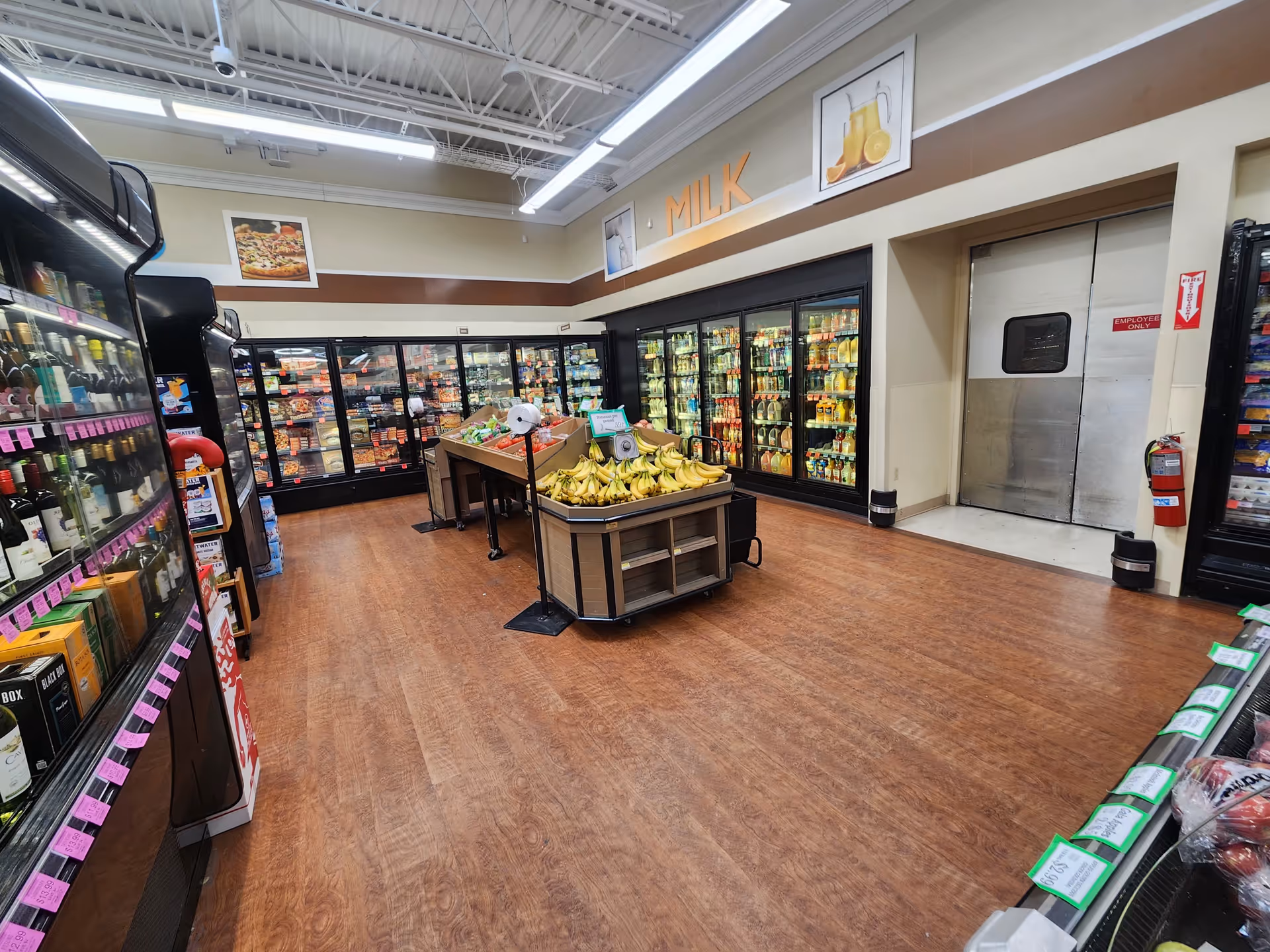 Interior of Discount Drug Mart grocery area with refrigerated displays and fruit display.