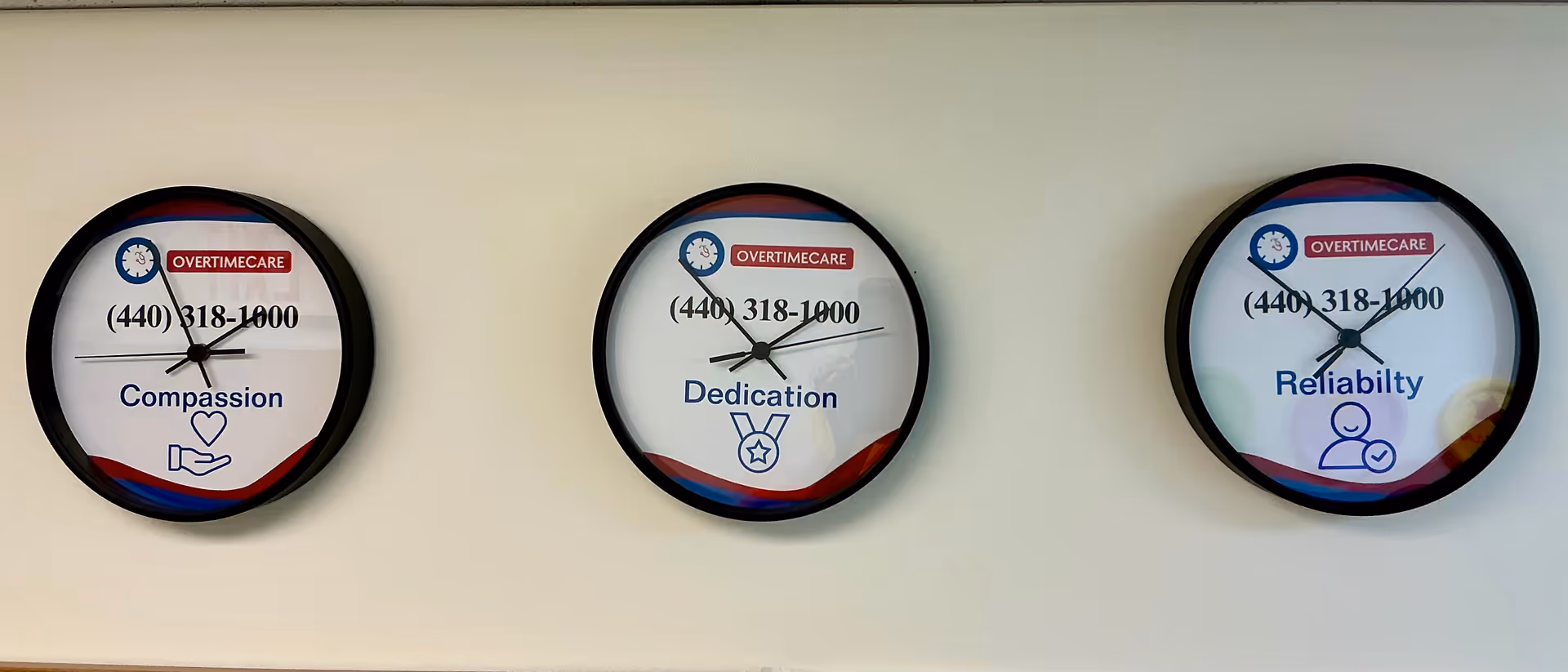 Three round clocks on a wall display Compassion, Dedication, and Reliability with OvertimeCare branding.