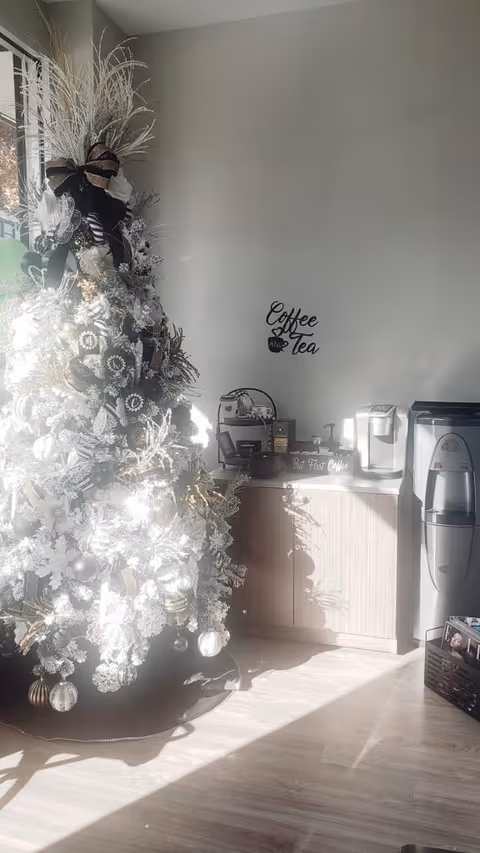 Interior common area featuring a large frosted Christmas tree and coffee station.