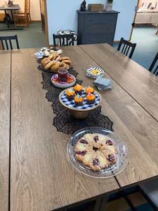 A long dining table with assorted pastries in a Right at Home dining room.