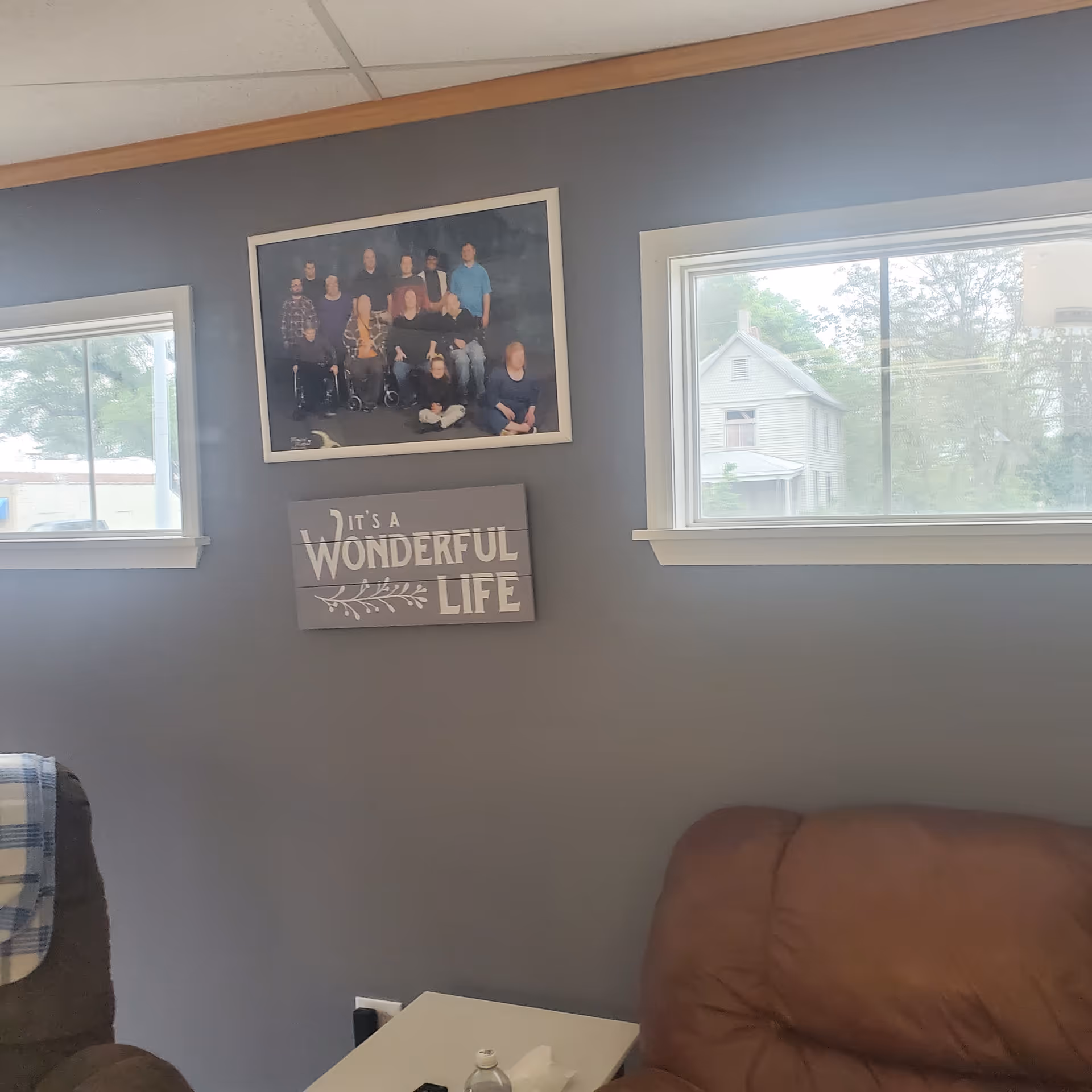 Interior living room with a framed group photo and a 'It's a Wonderful Life' sign.