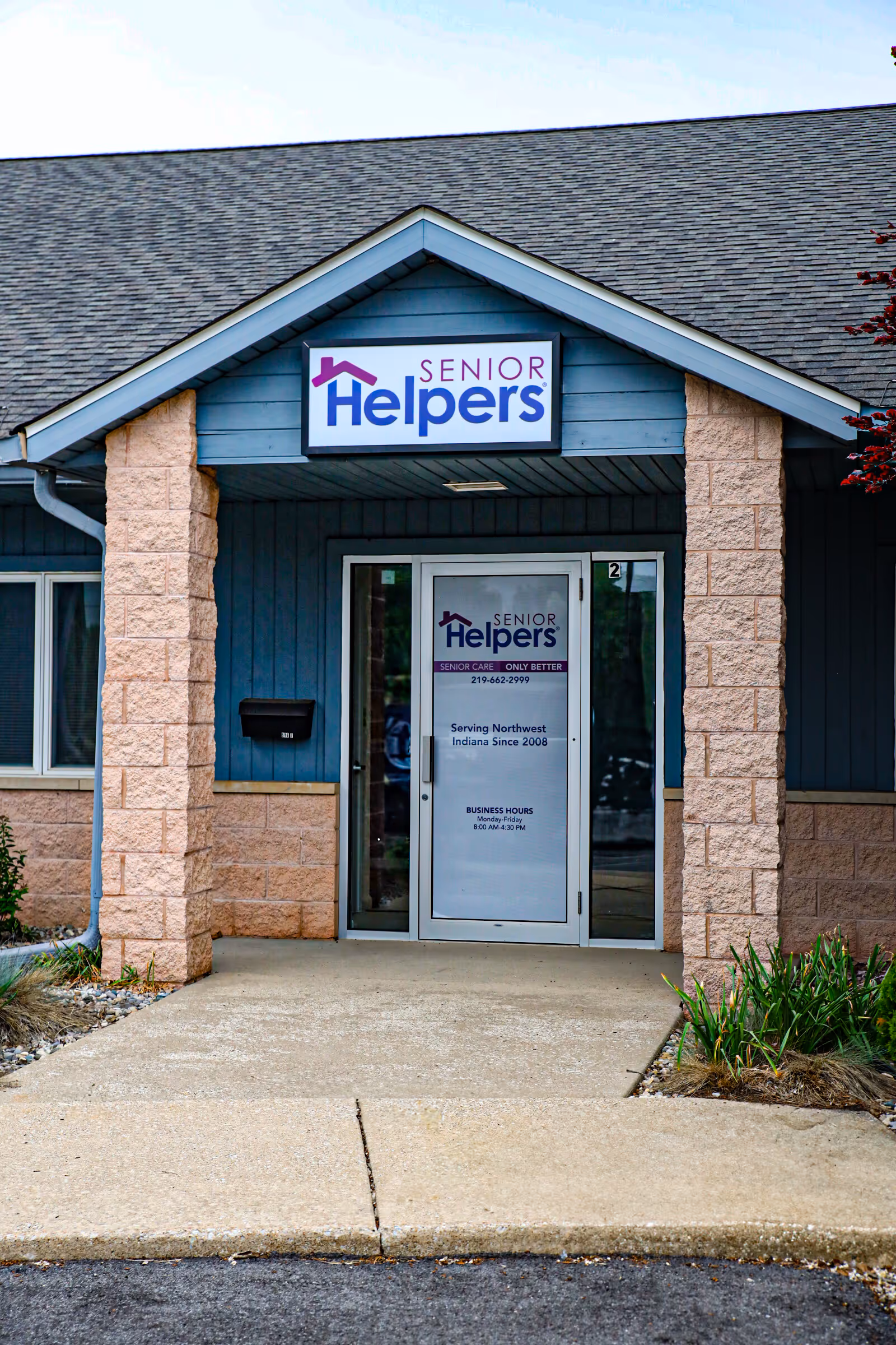 Front entrance of a Senior Helpers facility, blue exterior with a prominent sign above the door.