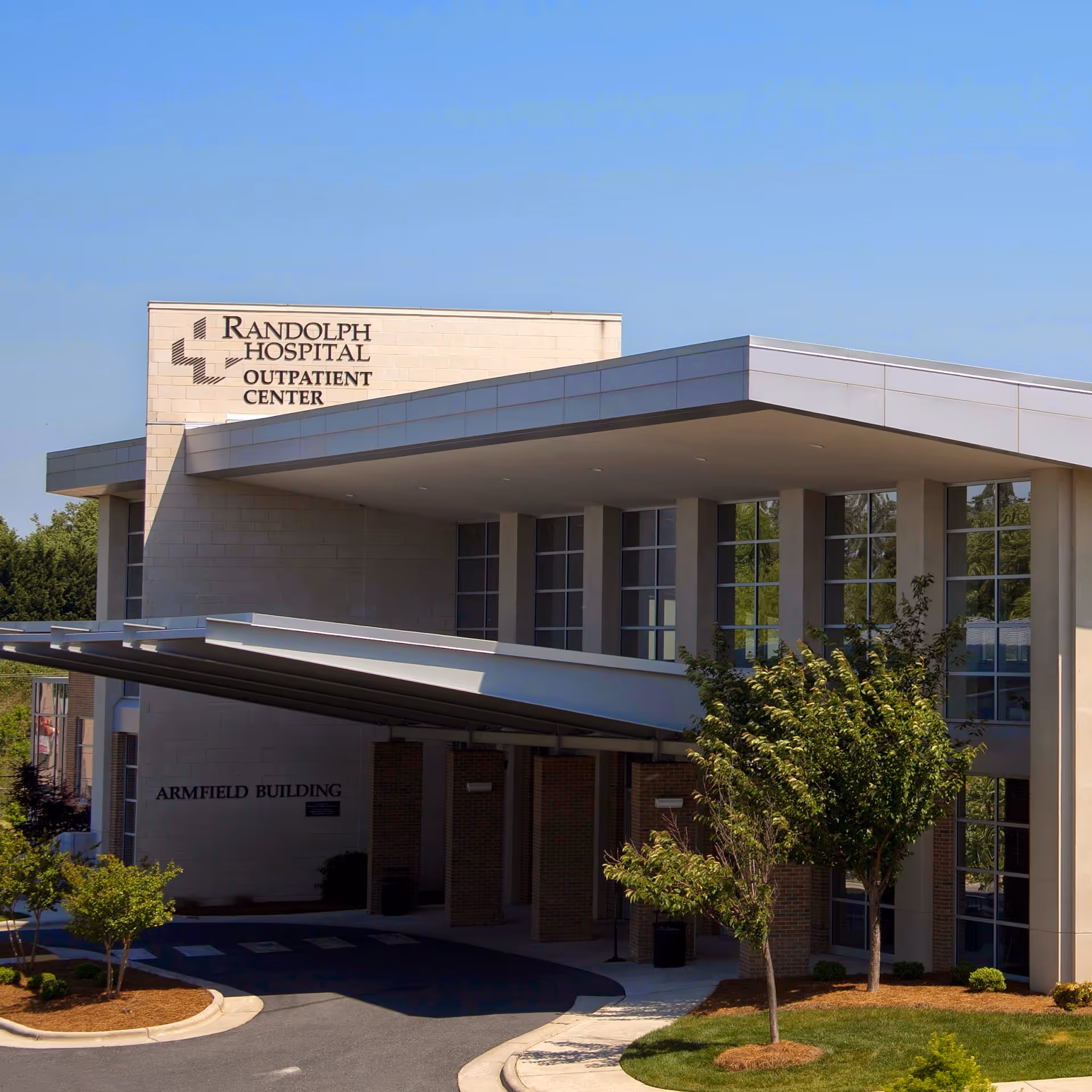 Modern hospital outpatient center exterior with signage and landscaping.