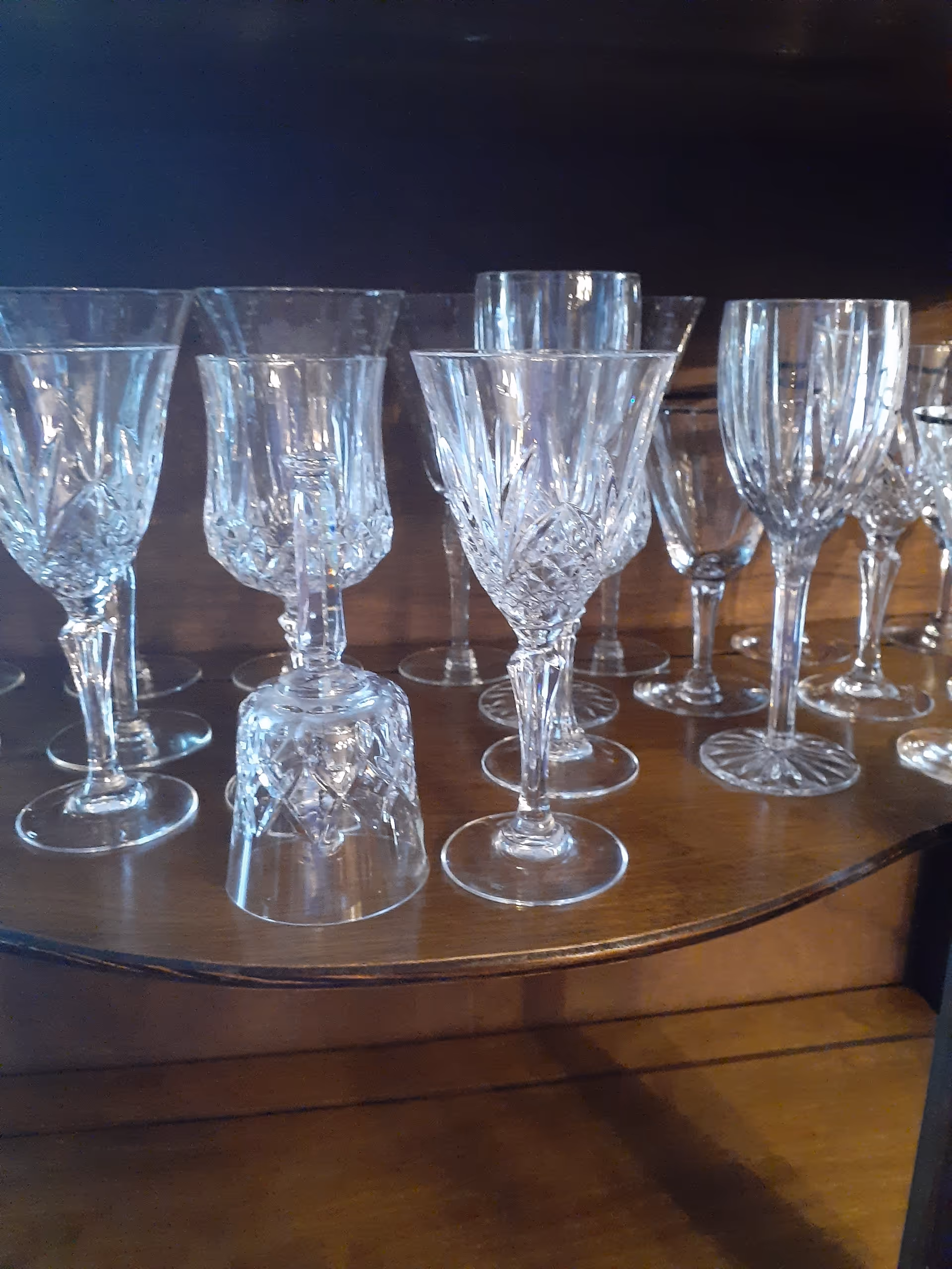 Crystal wine glasses arranged on a wooden table.