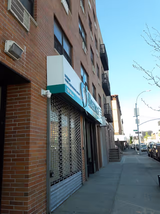 Bronx storefront with closed metal security gates and Regency Health Care sign on brick building.