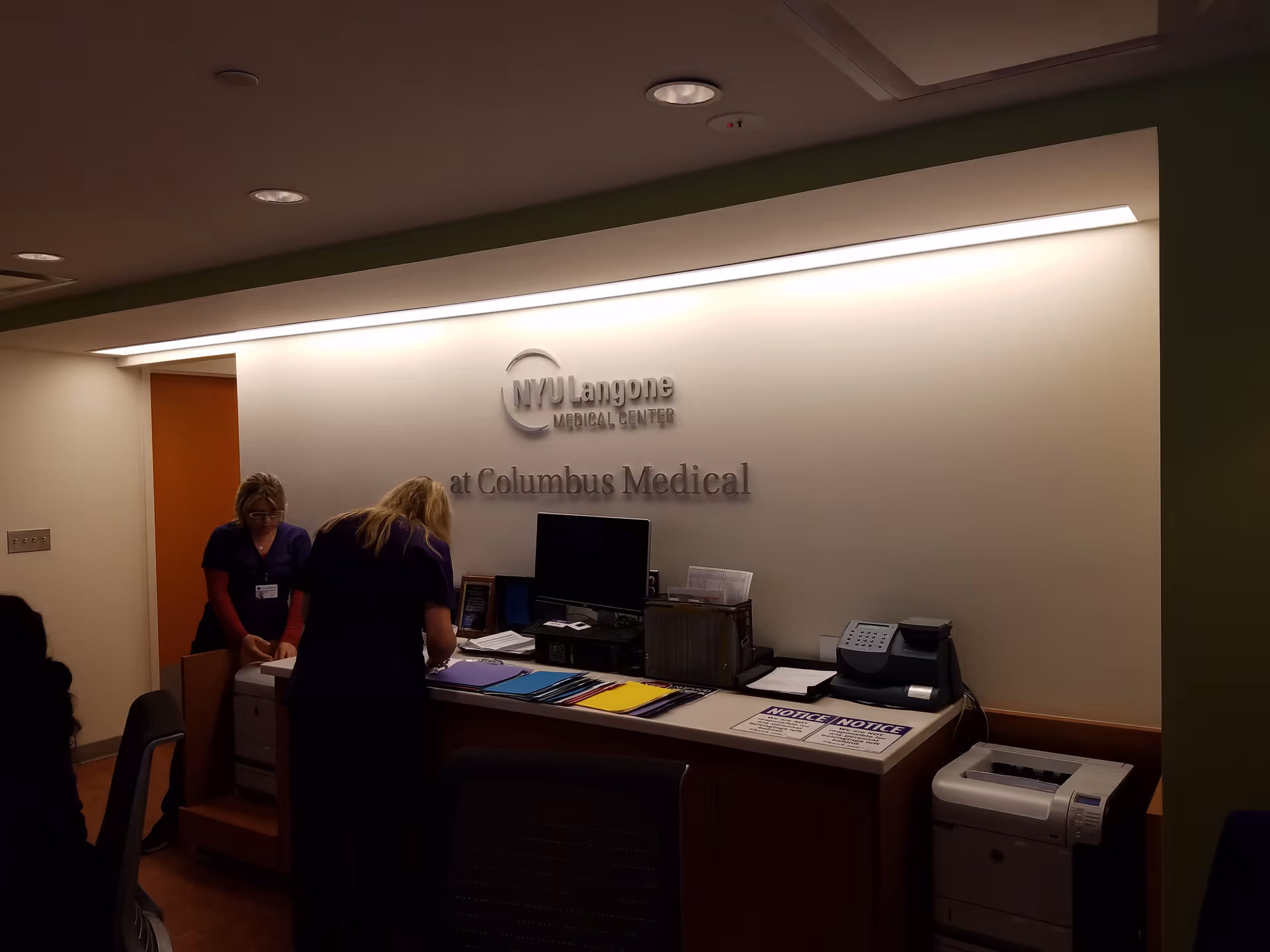 Reception area at NYU Langone Ambulatory Care Rego Park with staff at a service desk.