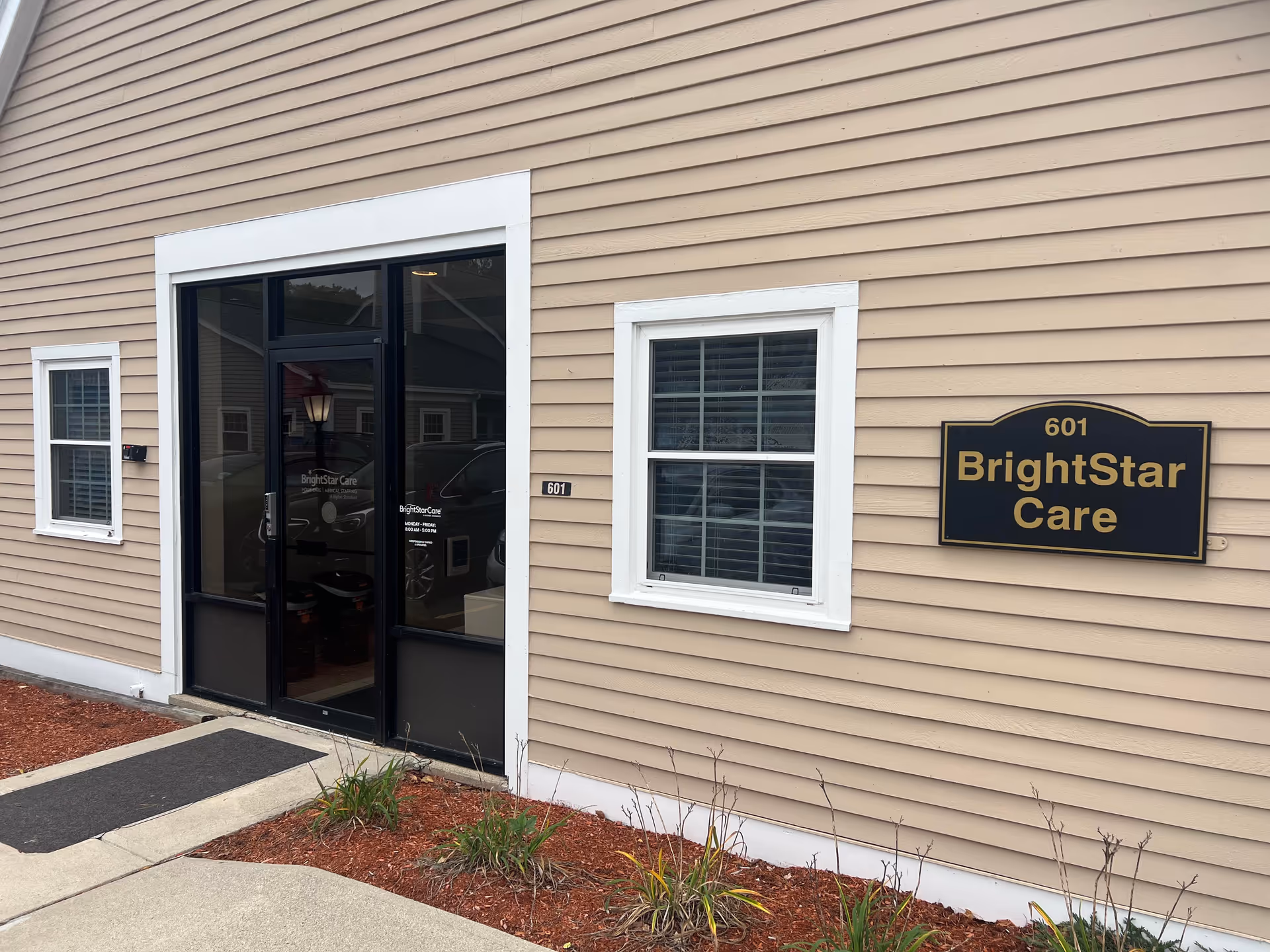Exterior view of BrightStar Care facility with glass entry door and wall sign.
