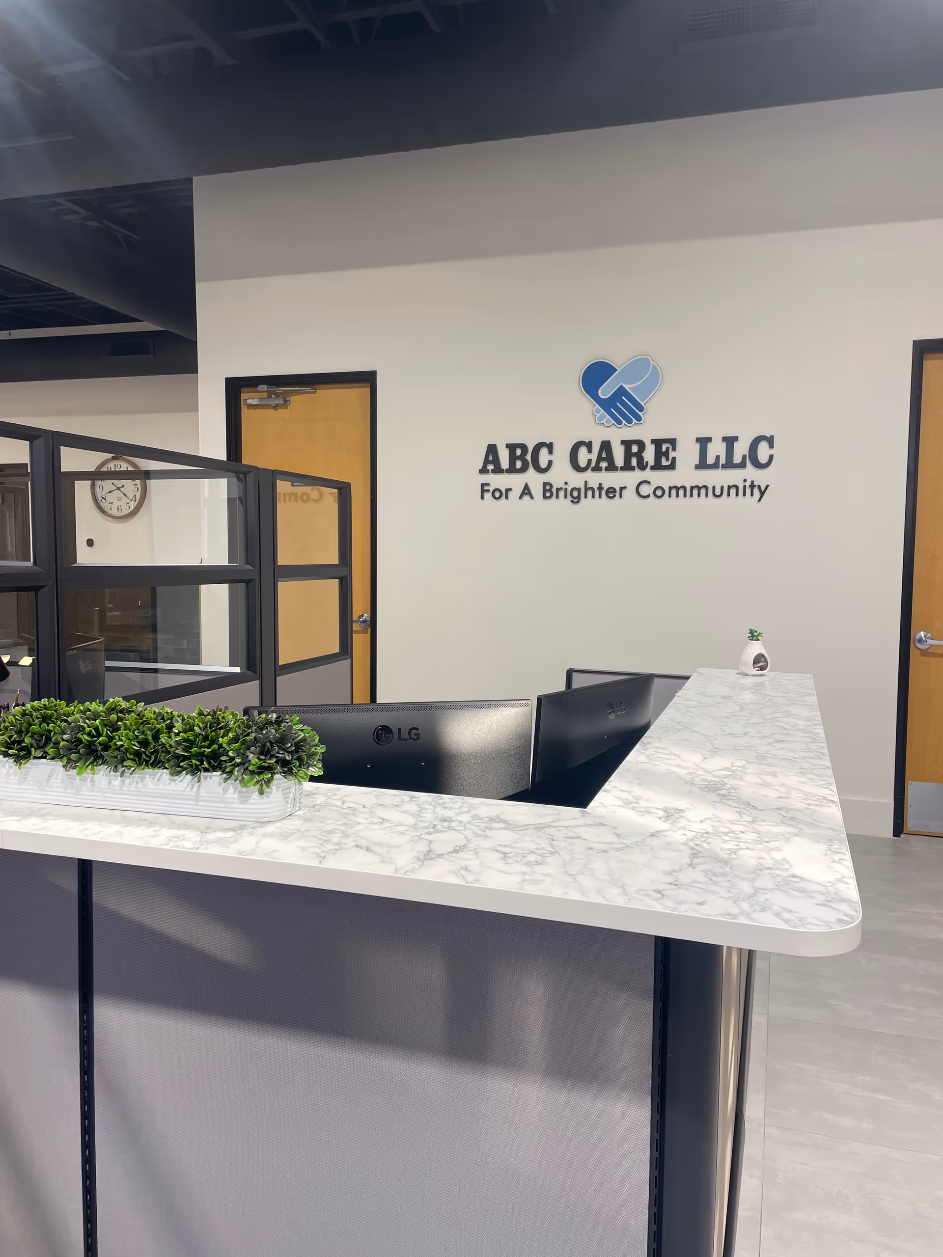 Marble-topped reception desk with ABC CARE LLC logo on the wall in the lobby.