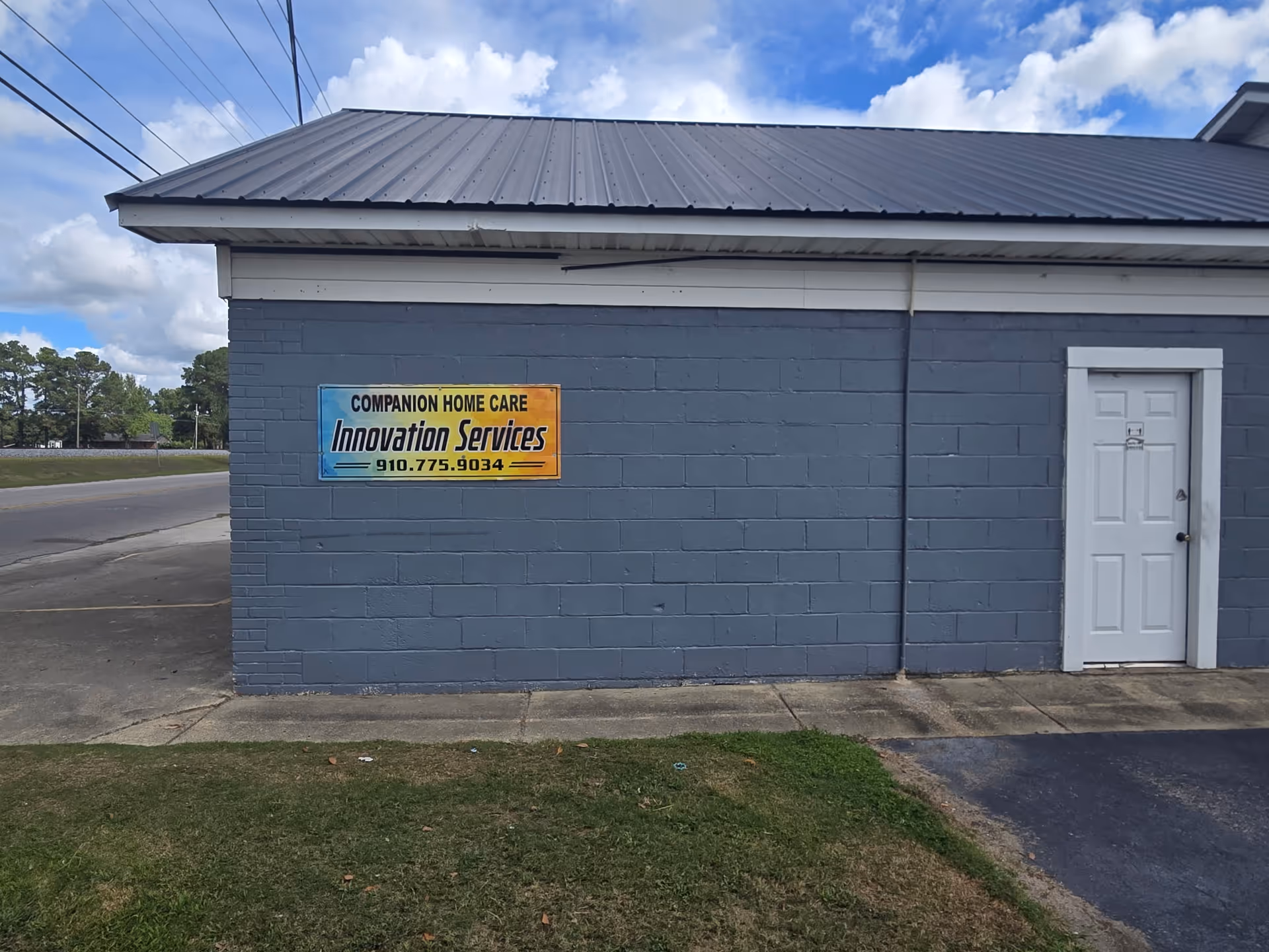Blue-gray building exterior with a sign for Companion Home Care Innovation Services and a door