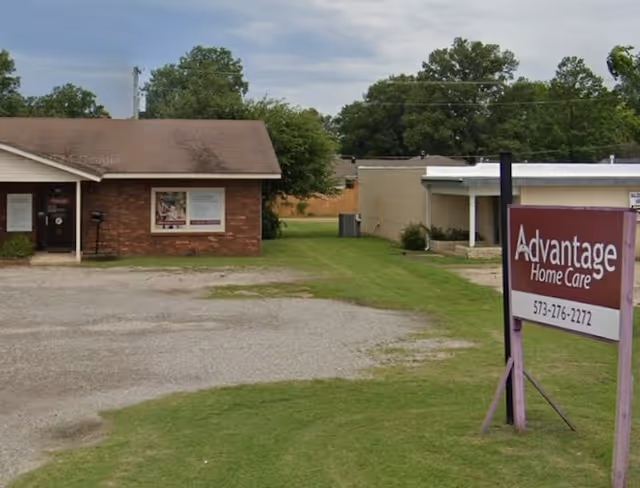 Exterior view of Advantage Home Care facility with a front lawn and sign.