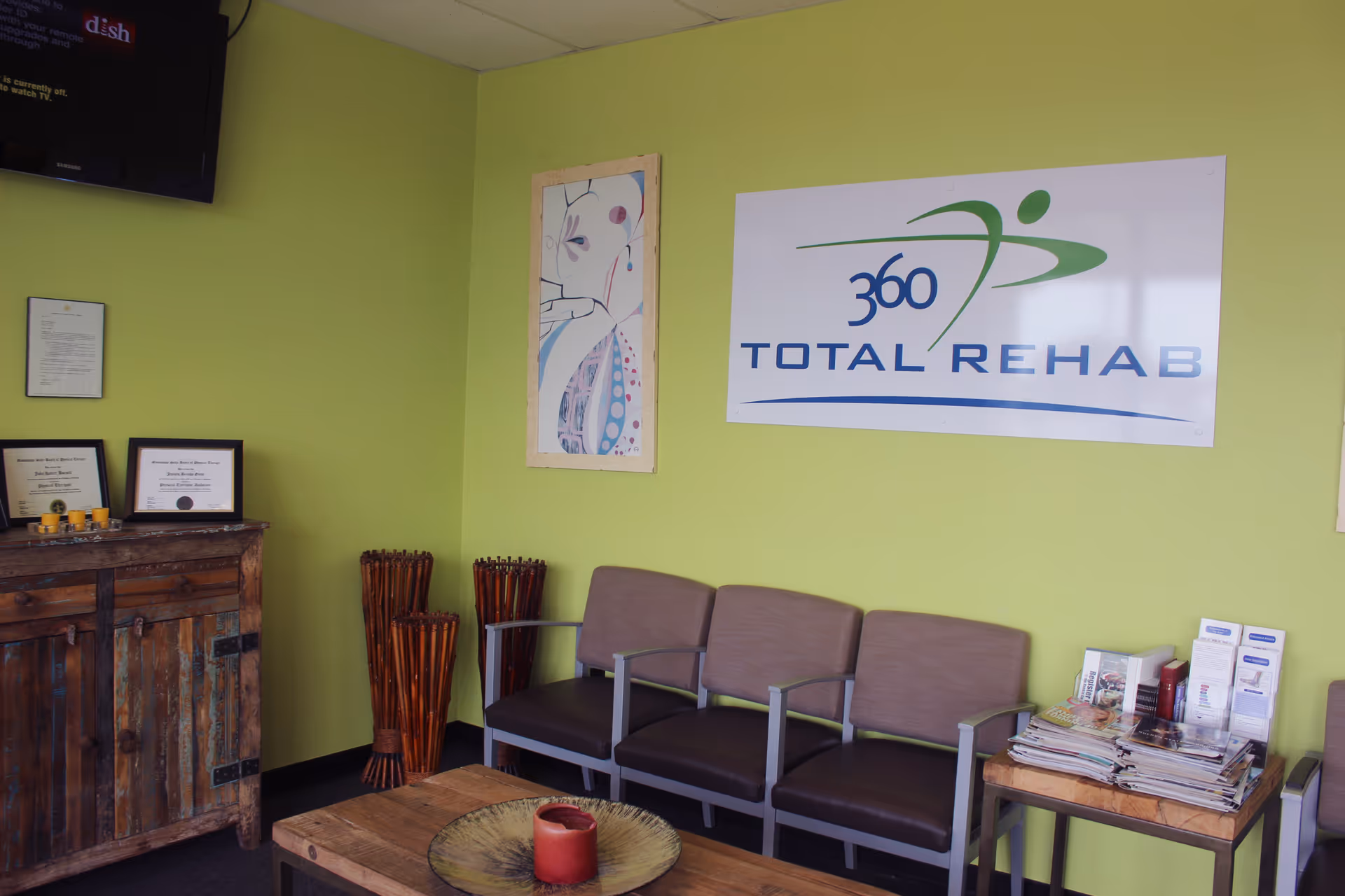 Green-walled waiting area with a 360 Total Rehab sign and chairs.