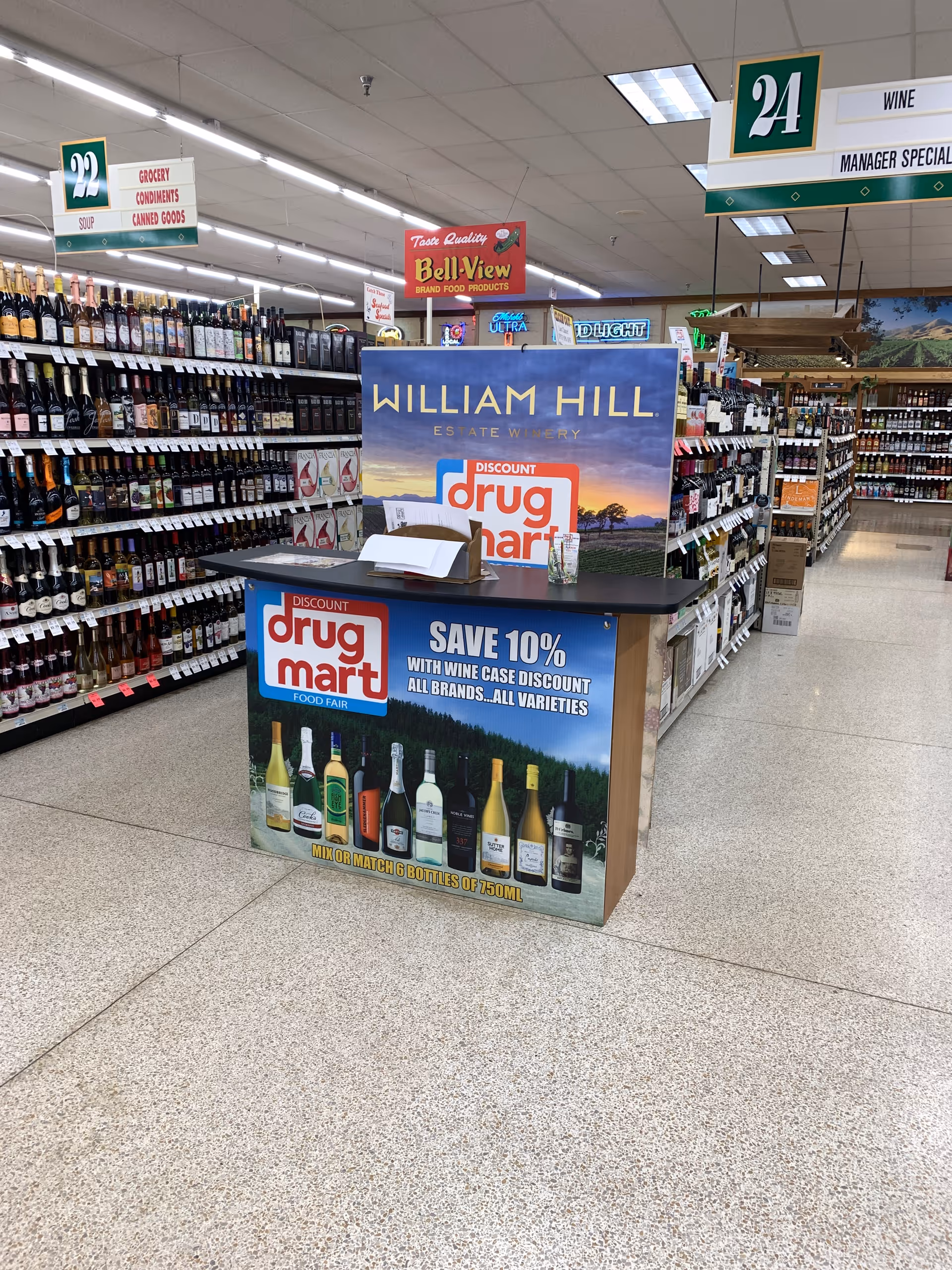 Inside Discount Drug Mart, a wine display island sits among aisles of bottled goods.