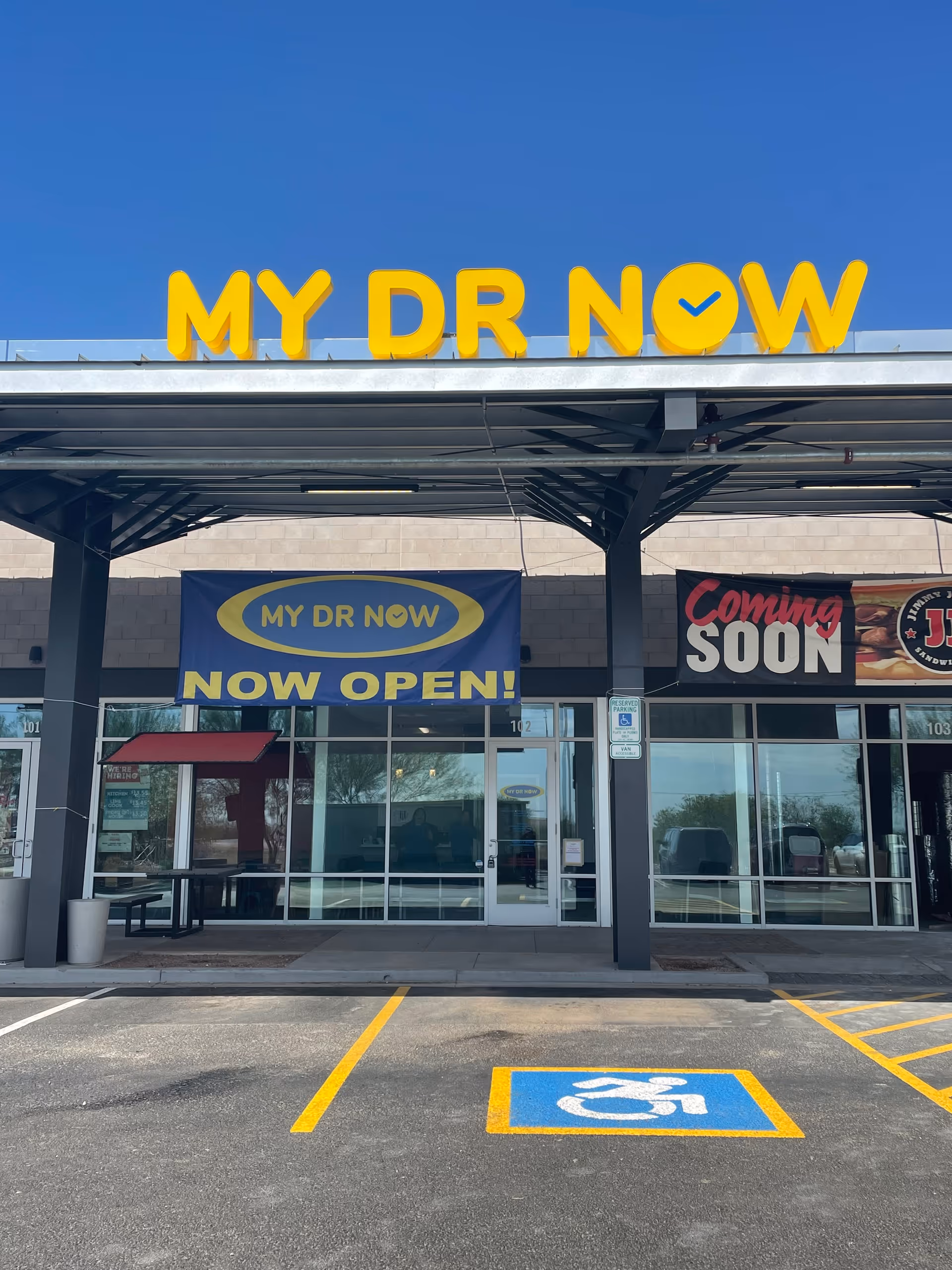 Exterior view of MY DR NOW storefront with banners reading Now Open and Coming Soon.