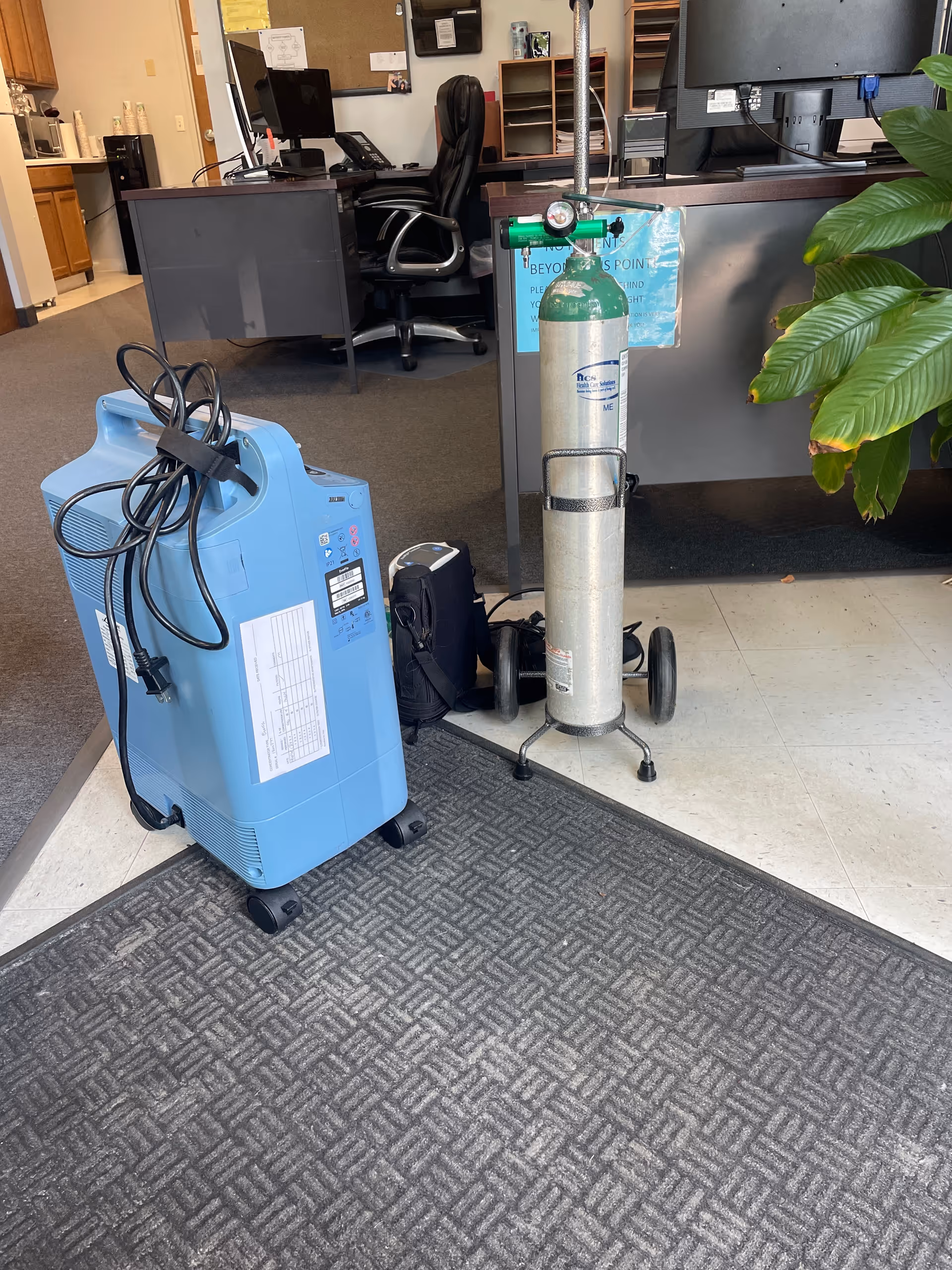 Interior facility lobby with a blue medical device and an oxygen cylinder near reception.