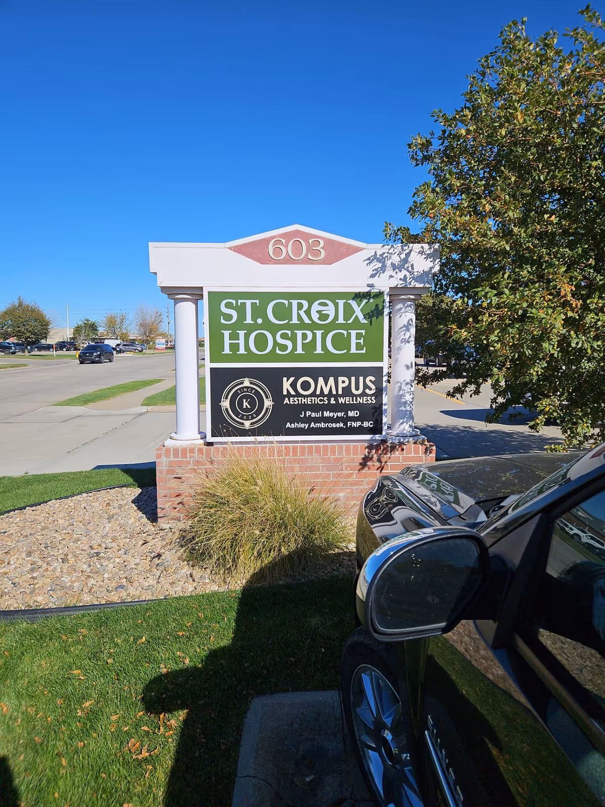 Front exterior sign for St. Croix Hospice with a parked car and blue sky