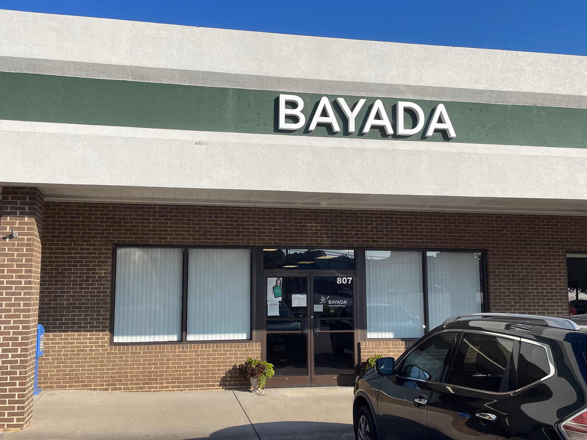 BAYADA Home Health storefront exterior with large sign and a parked car.