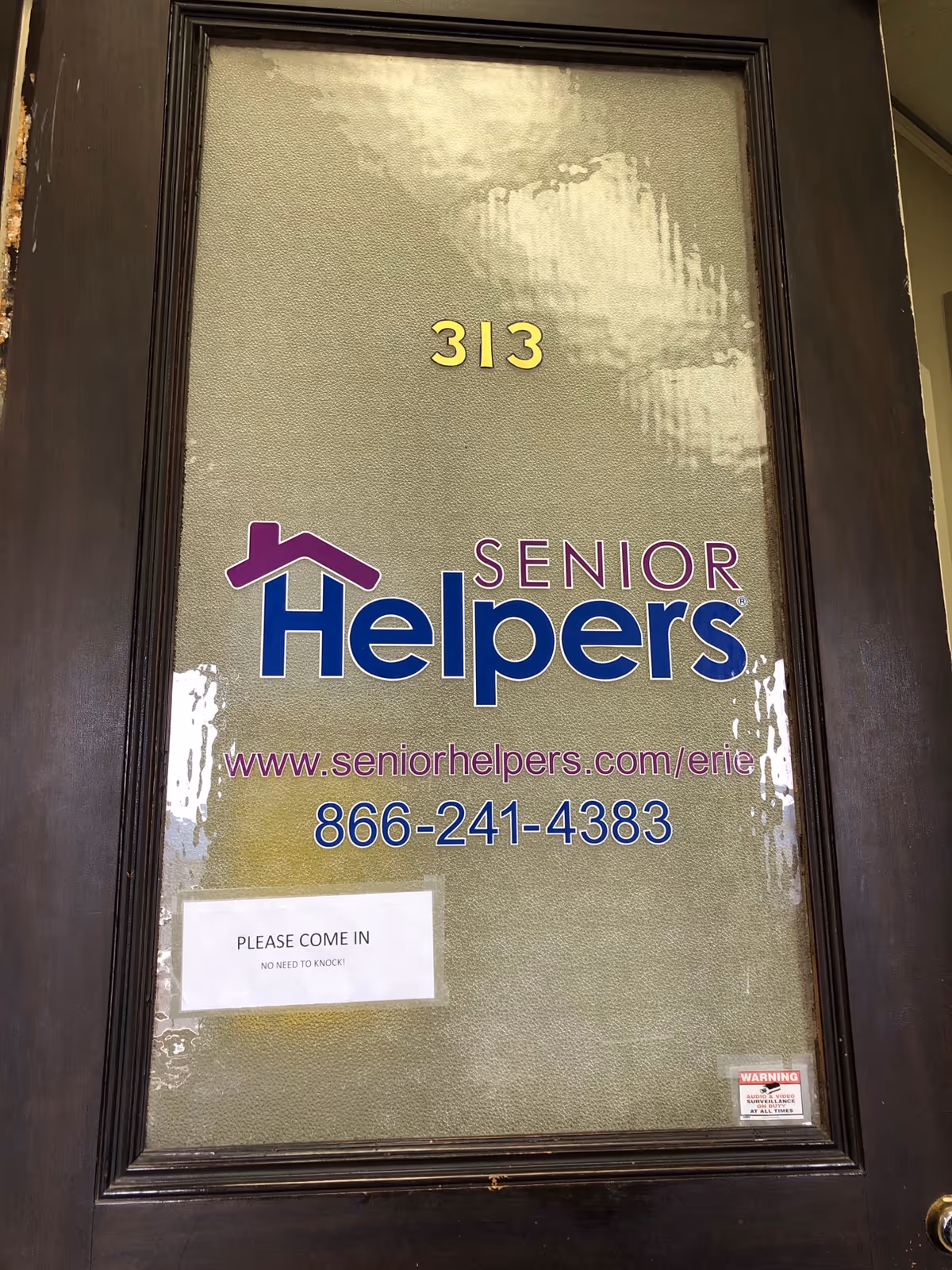 Frosted glass door displays Senior Helpers sign, room 313, and contact details.