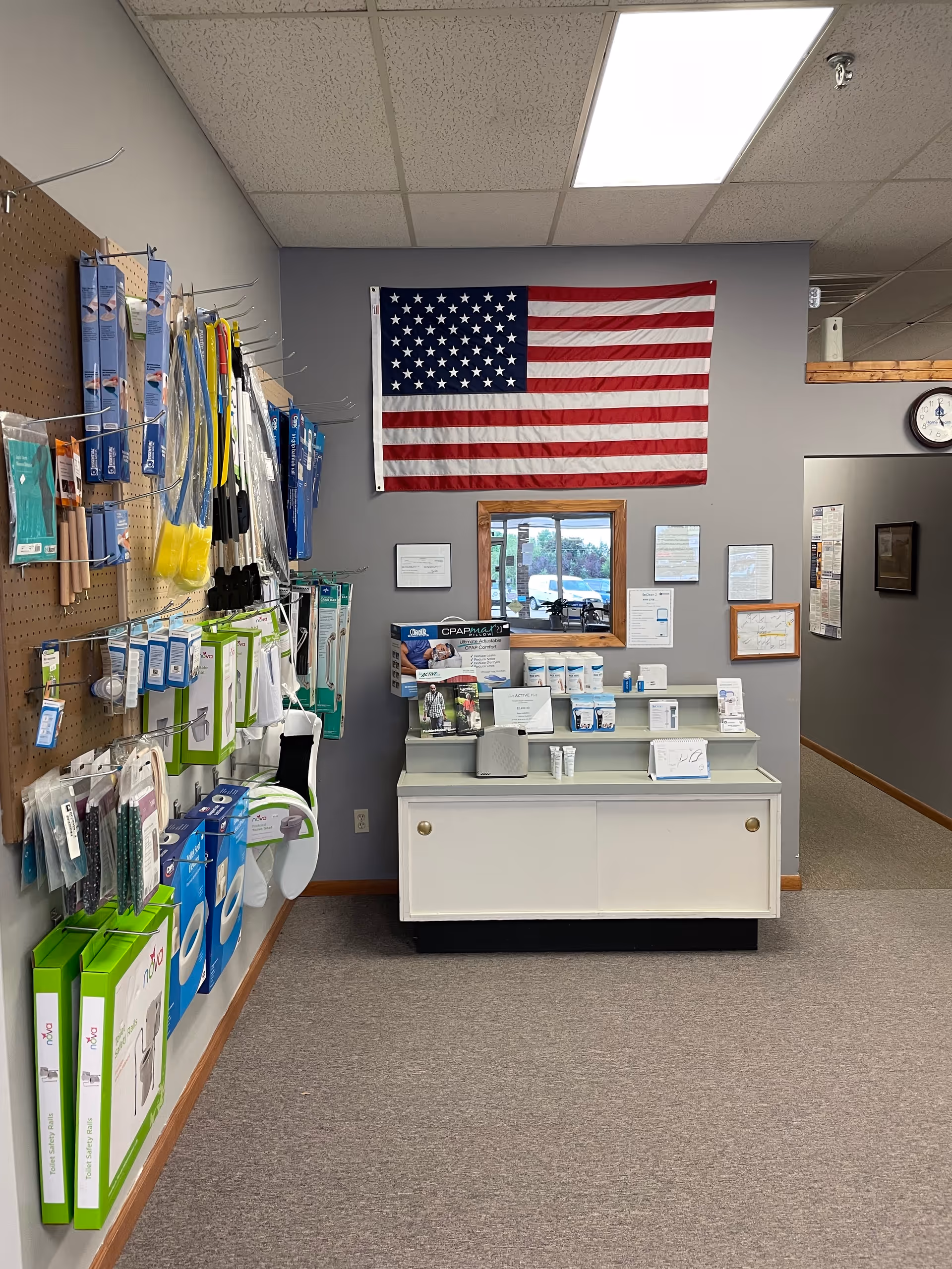 Interior supply area with medical equipment on shelving and an American flag on the wall.