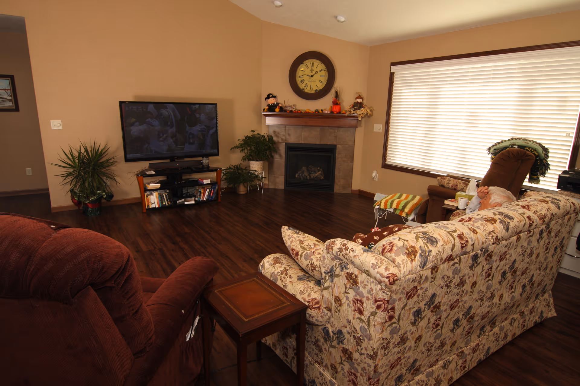 Cozy living room at Helen's House Grand Chute with sofa, fireplace, and plants.