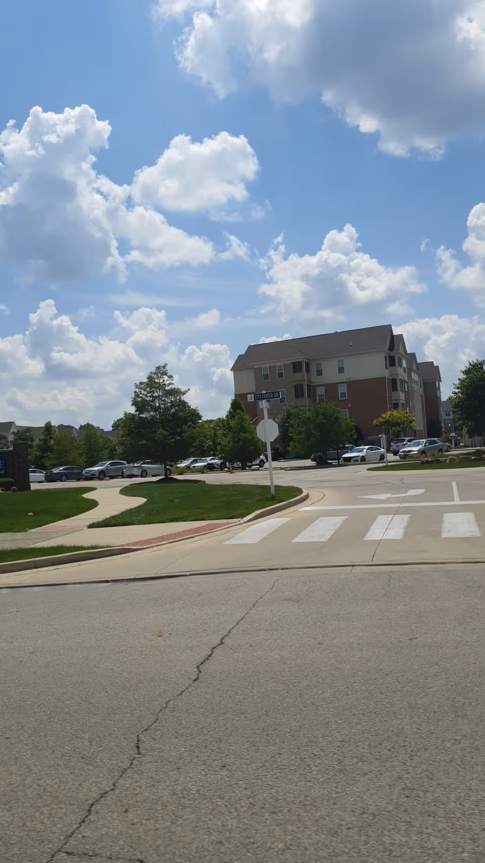 Exterior view of BrightStar Care senior living building with parking and crosswalk.