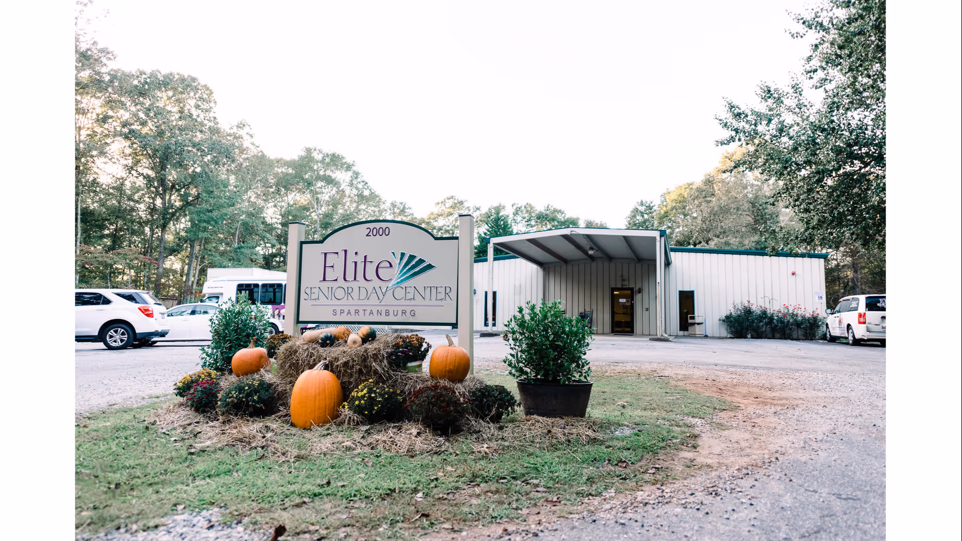Exterior view of Elite Senior Day Center with pumpkins and a front entrance sign.