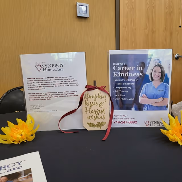 Two promotional display boards with SYNERGY HomeCare brochures on a table inside a facility.