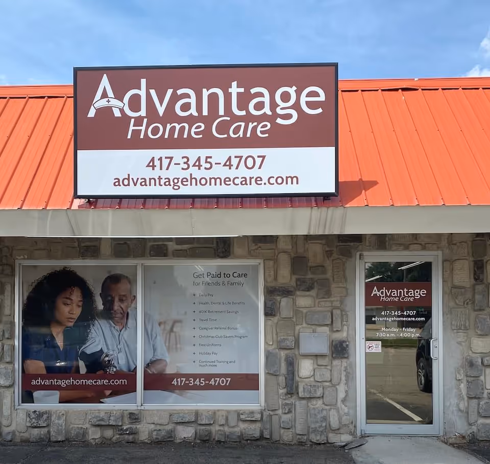 Exterior view of Advantage Home Care storefront with large sign, stone facade, and posters in windows.