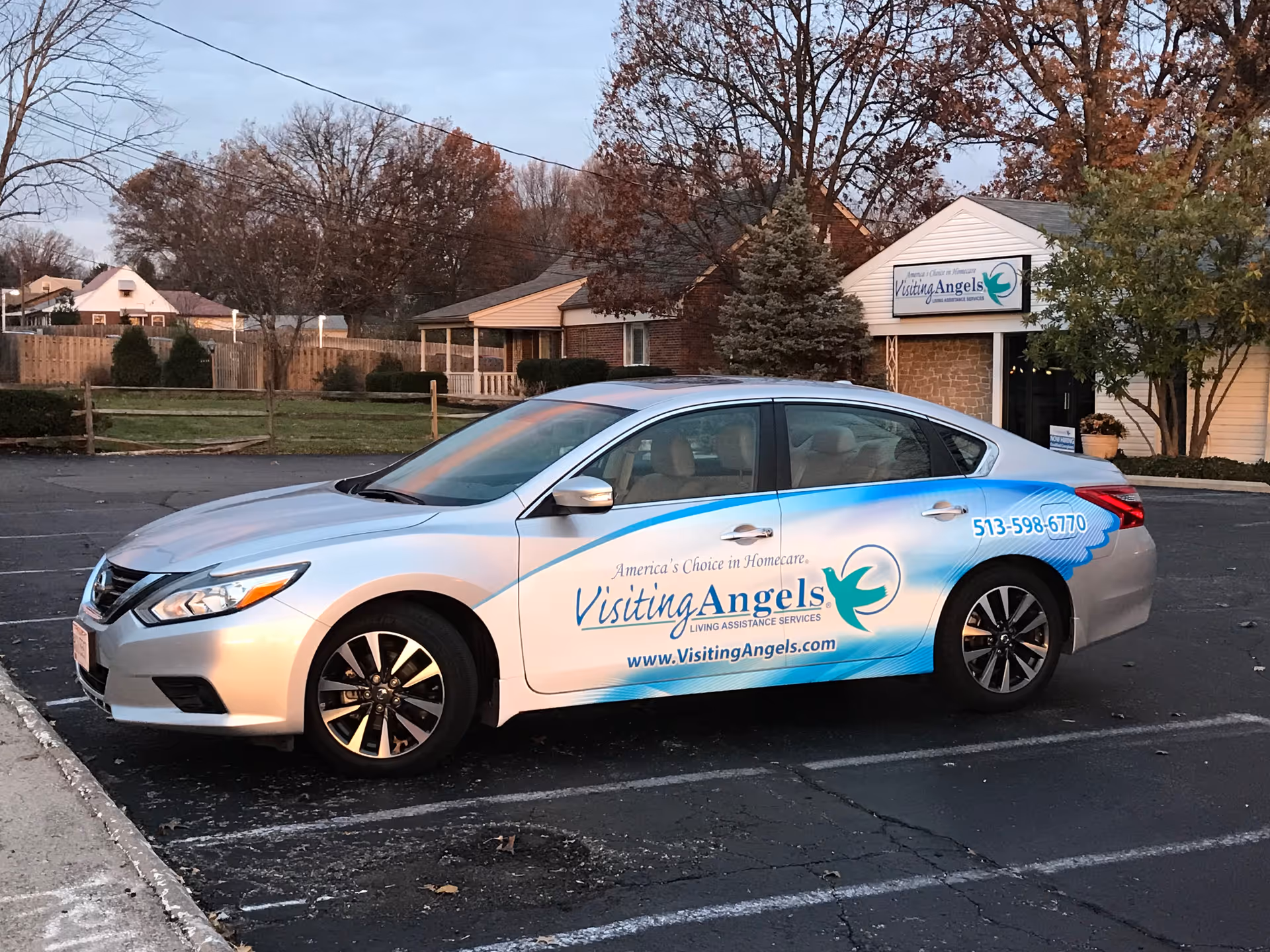 A branded Visiting Angels car parked in front of a senior home building.