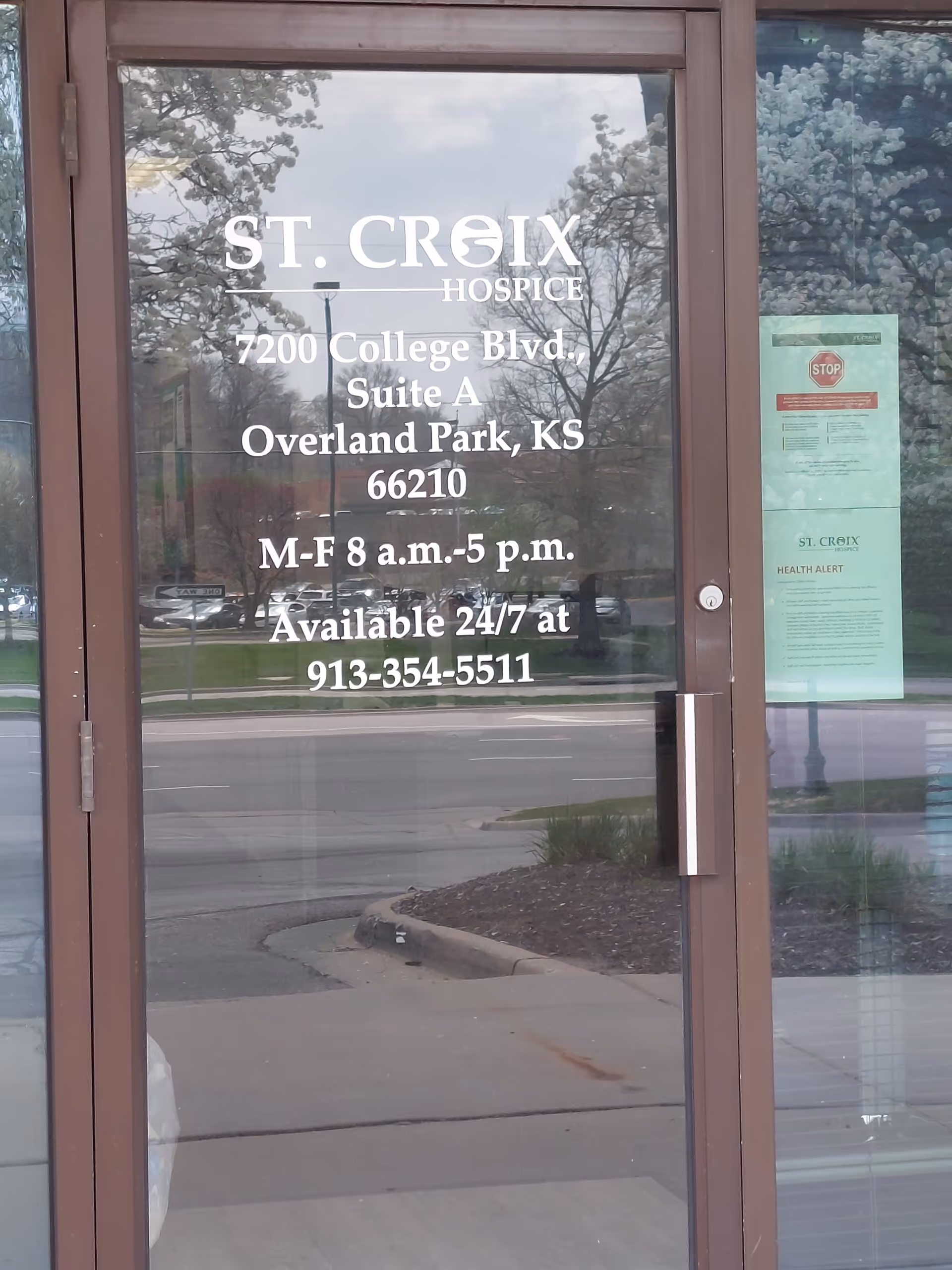 Glass entrance door with St. Croix Hospice signage and hours.
