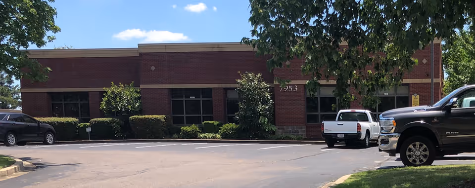 Brick Caris Healthcare building with parking lot in front.