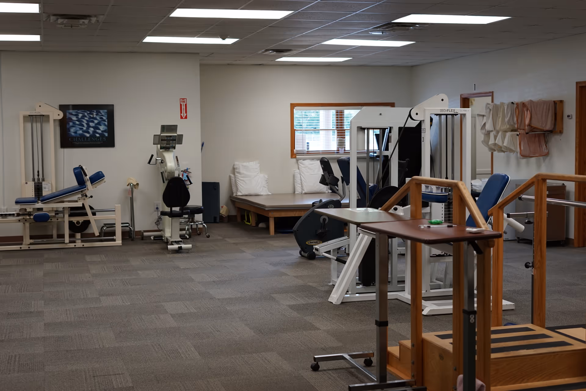 Interior of a senior gym with weight machines, benches, and open exercise area.