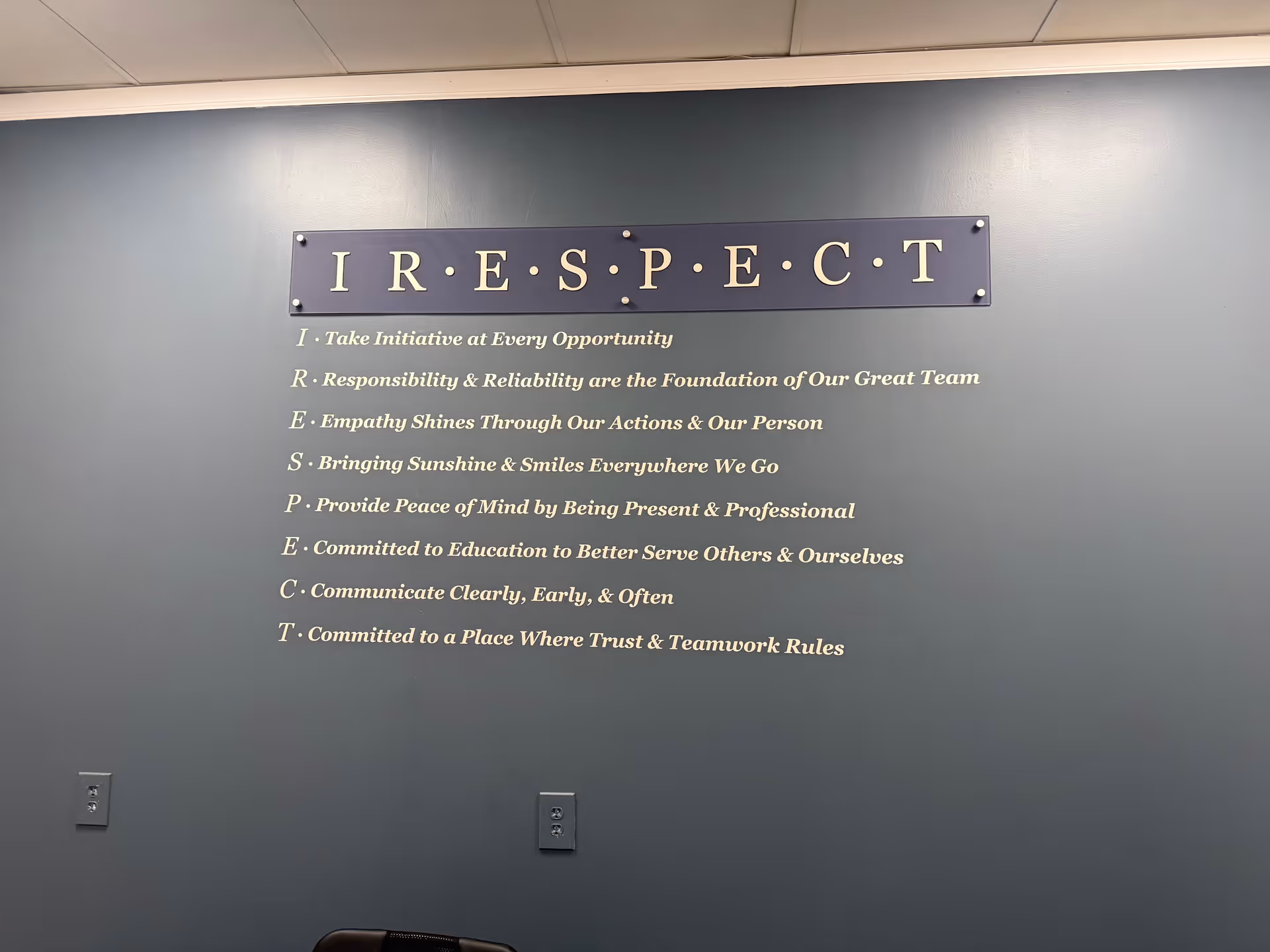Blue interior wall with a RESPECT sign and eight motto lines beneath it.