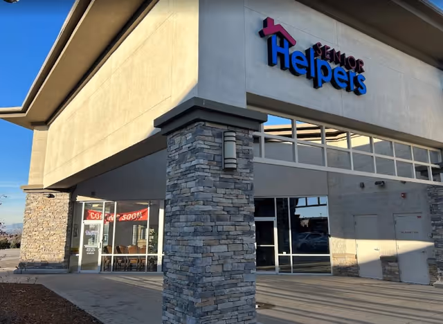 Exterior view of a Senior Helpers facility featuring stone columns and glass entrance.