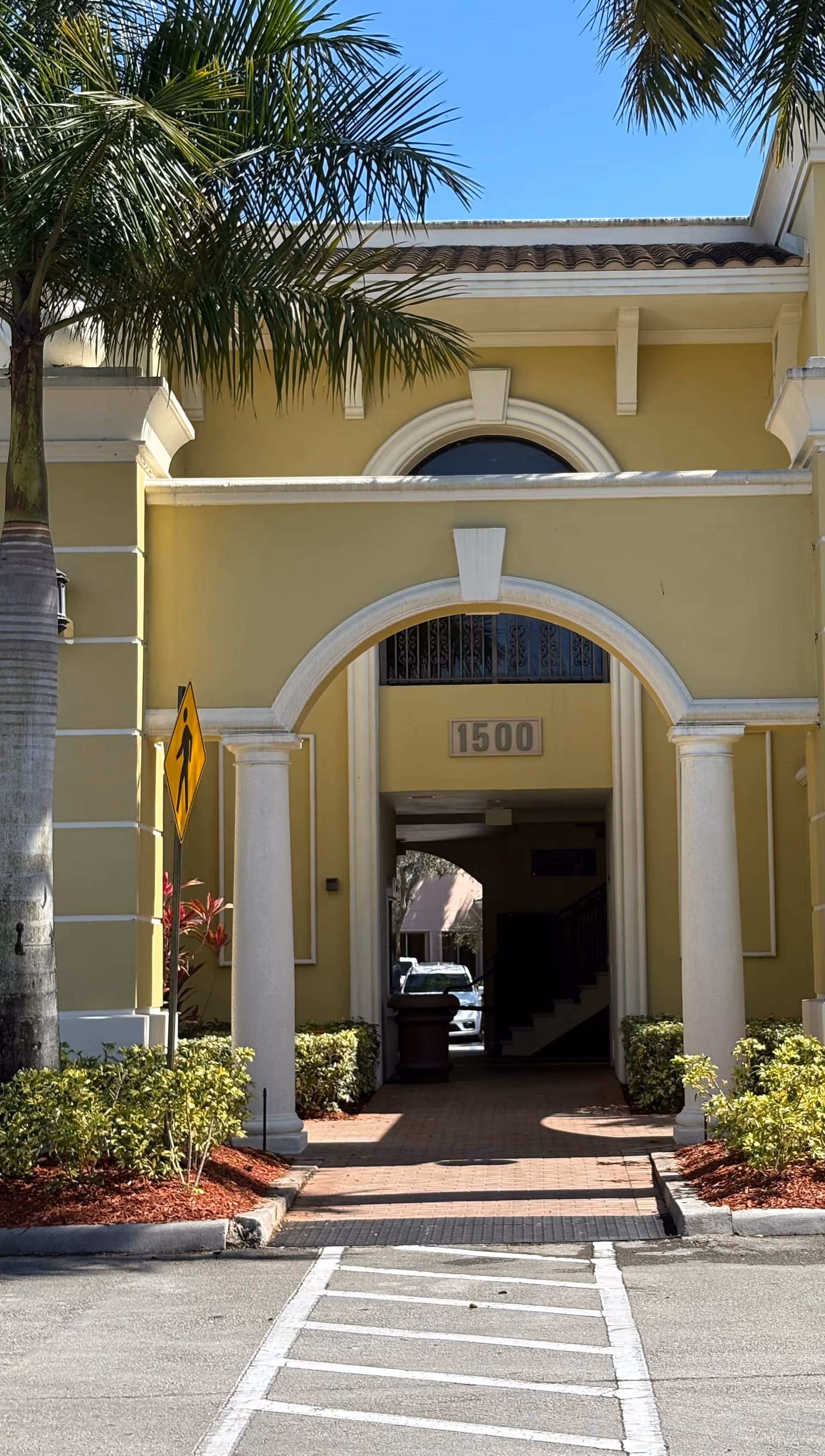 DavidStar Home Care front entrance with arches, columns, palms, and yellow exterior.