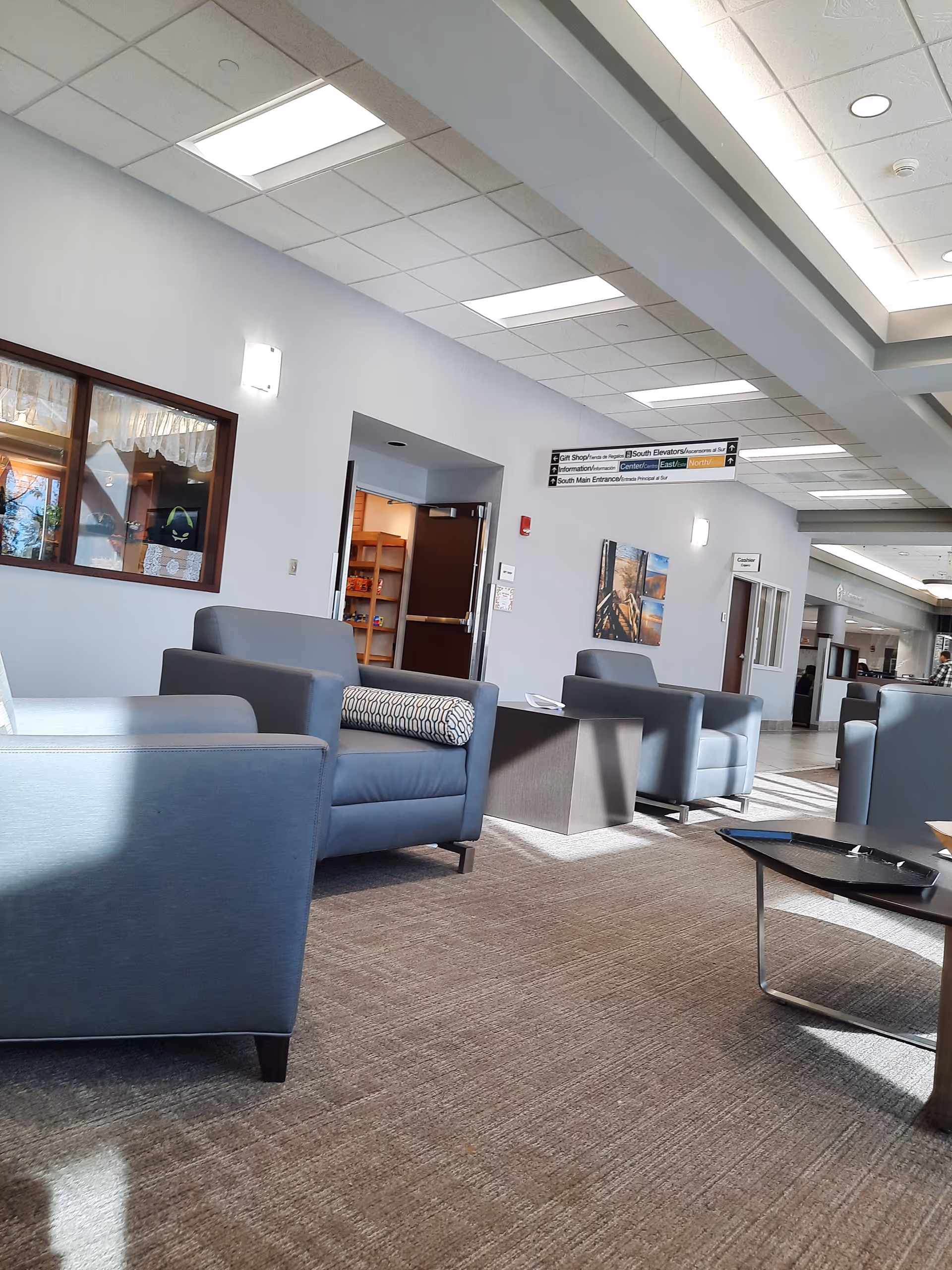 St. Catherine Hospital lobby with blue lounge chairs, signage, and overhead fluorescent lighting.