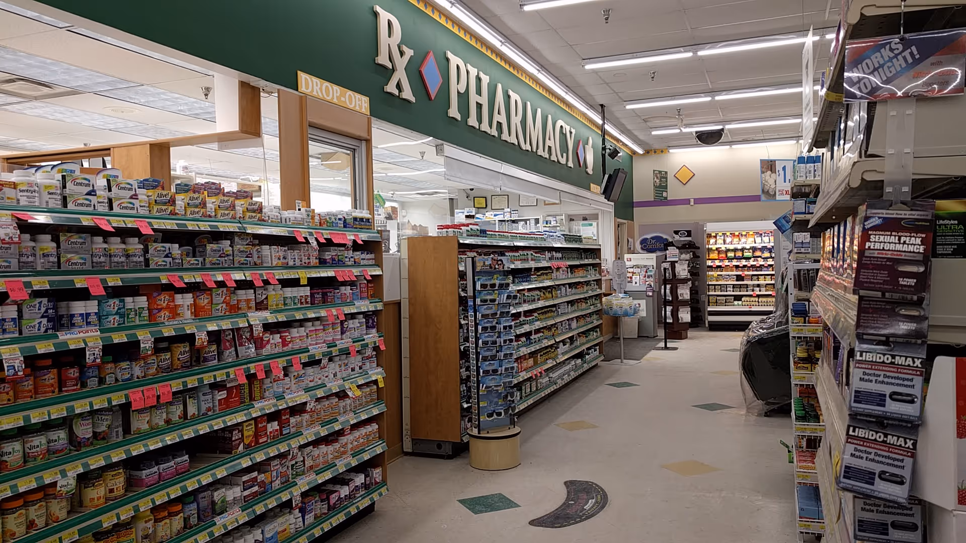 Inside Discount Drug Mart pharmacy, shelves stocked with medications beneath a large RX sign.