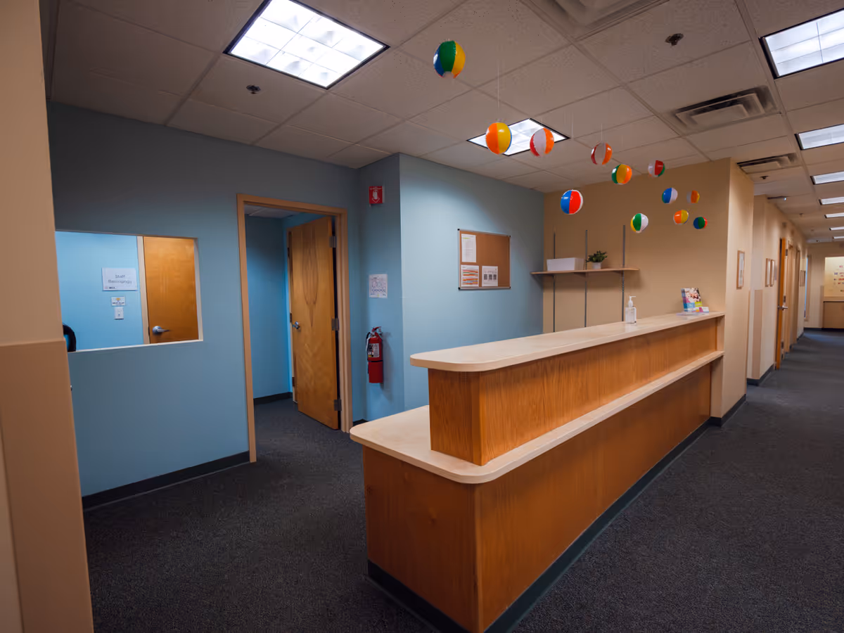 Indoor reception desk along a hallway in a senior living facility.