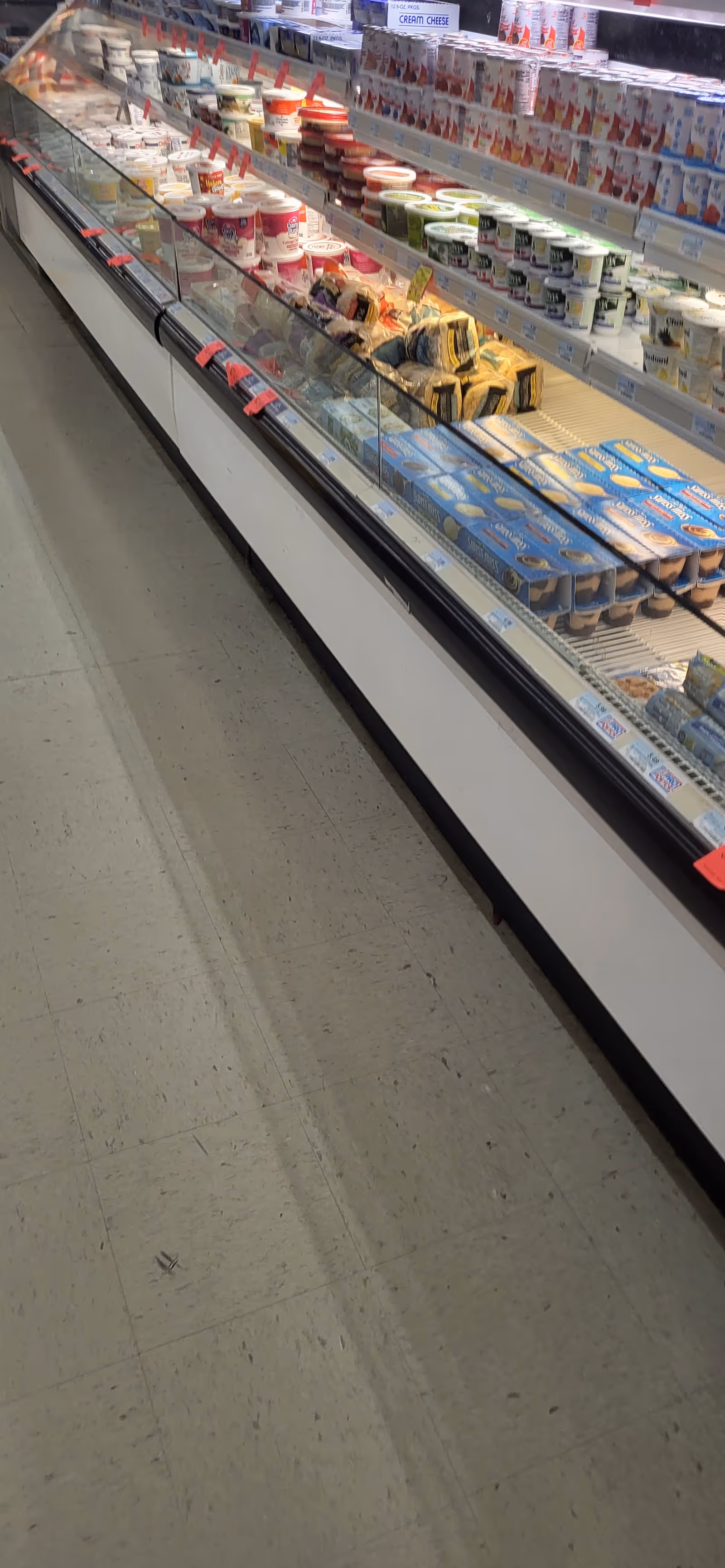 Grocery store aisle showing refrigerated dairy and yogurt products on shelves.