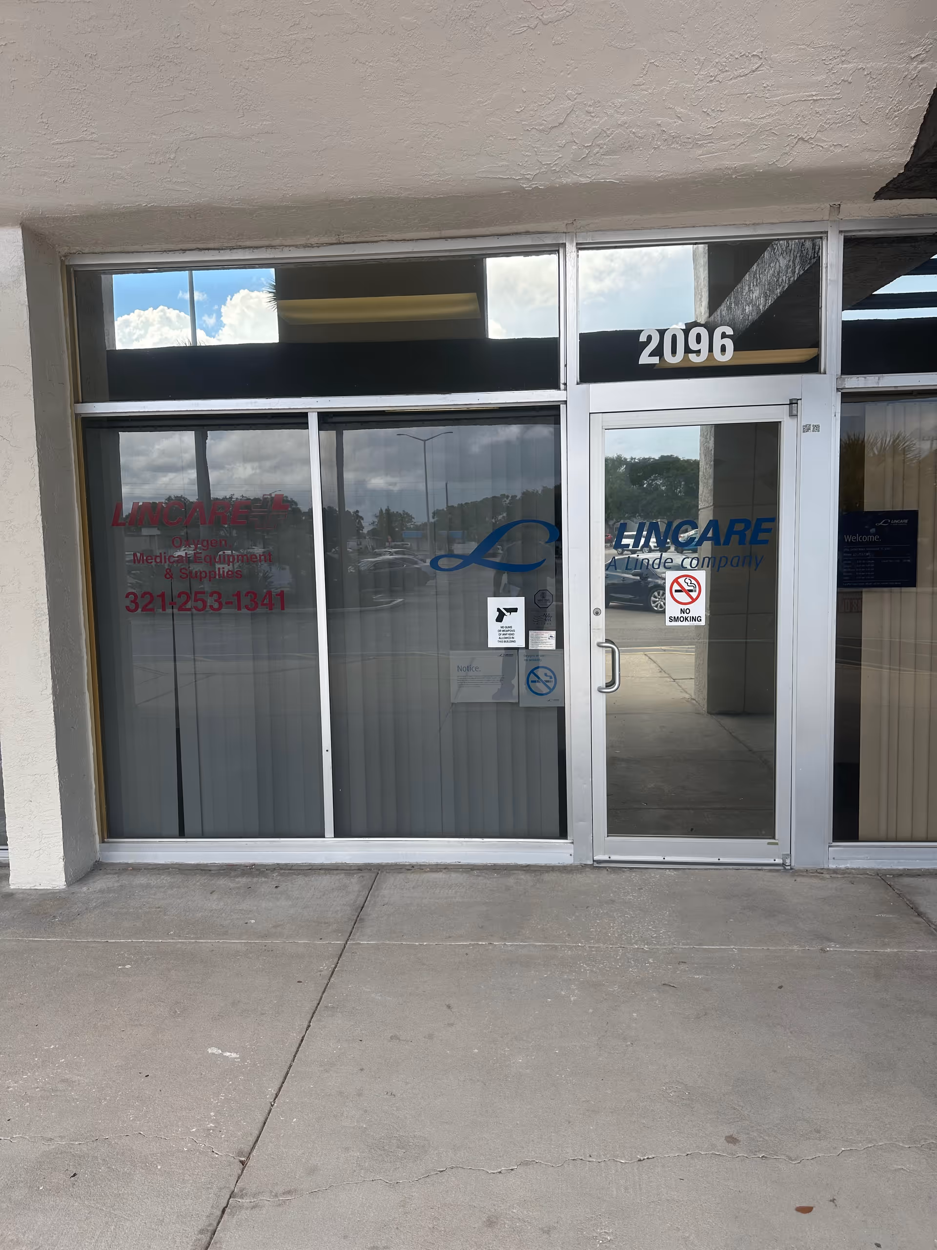 Glass storefront entrance with Lincare signage and large windows in a concrete building.