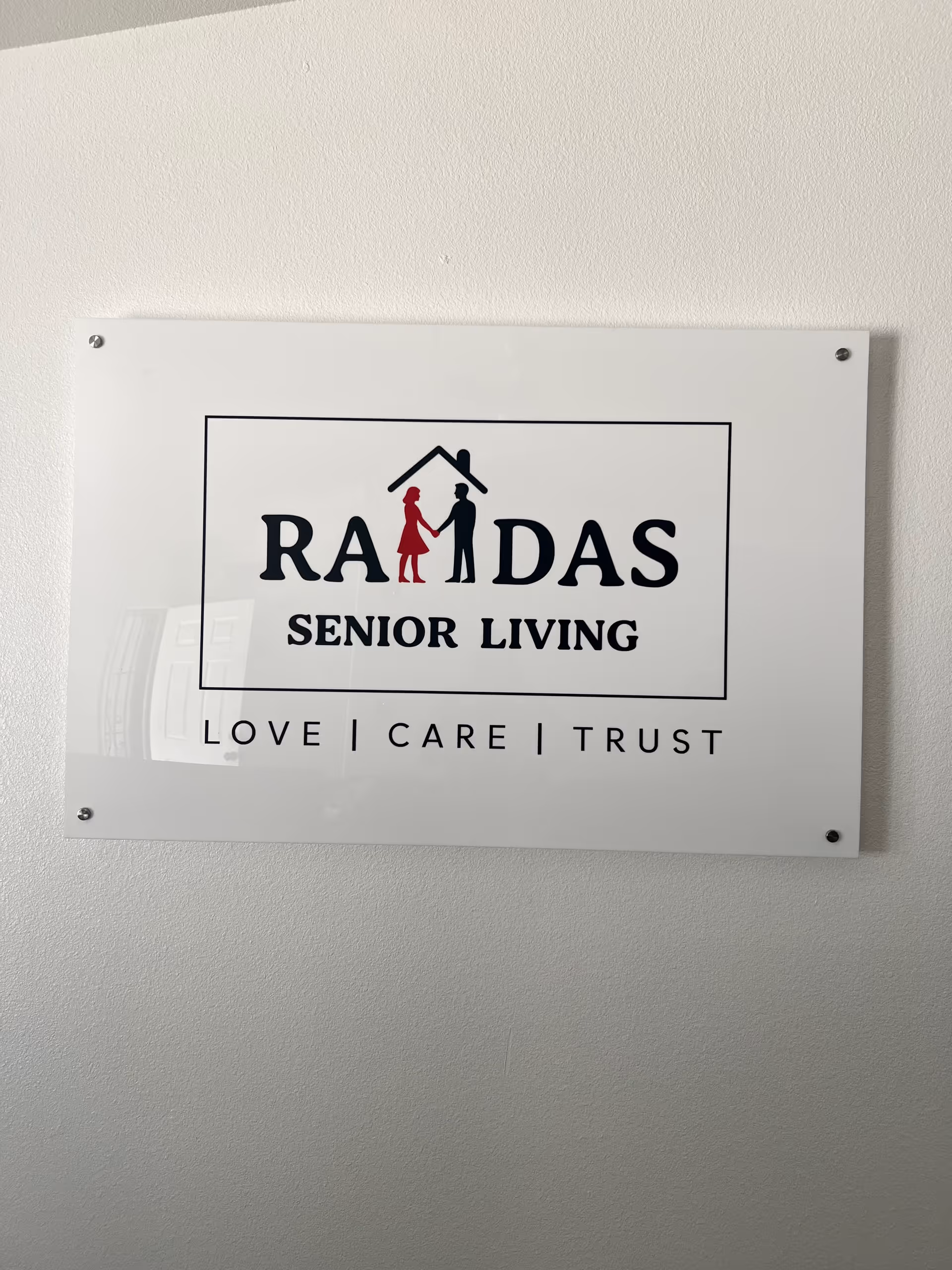 A wall placard displaying Ramdas Senior Living logo and motto.